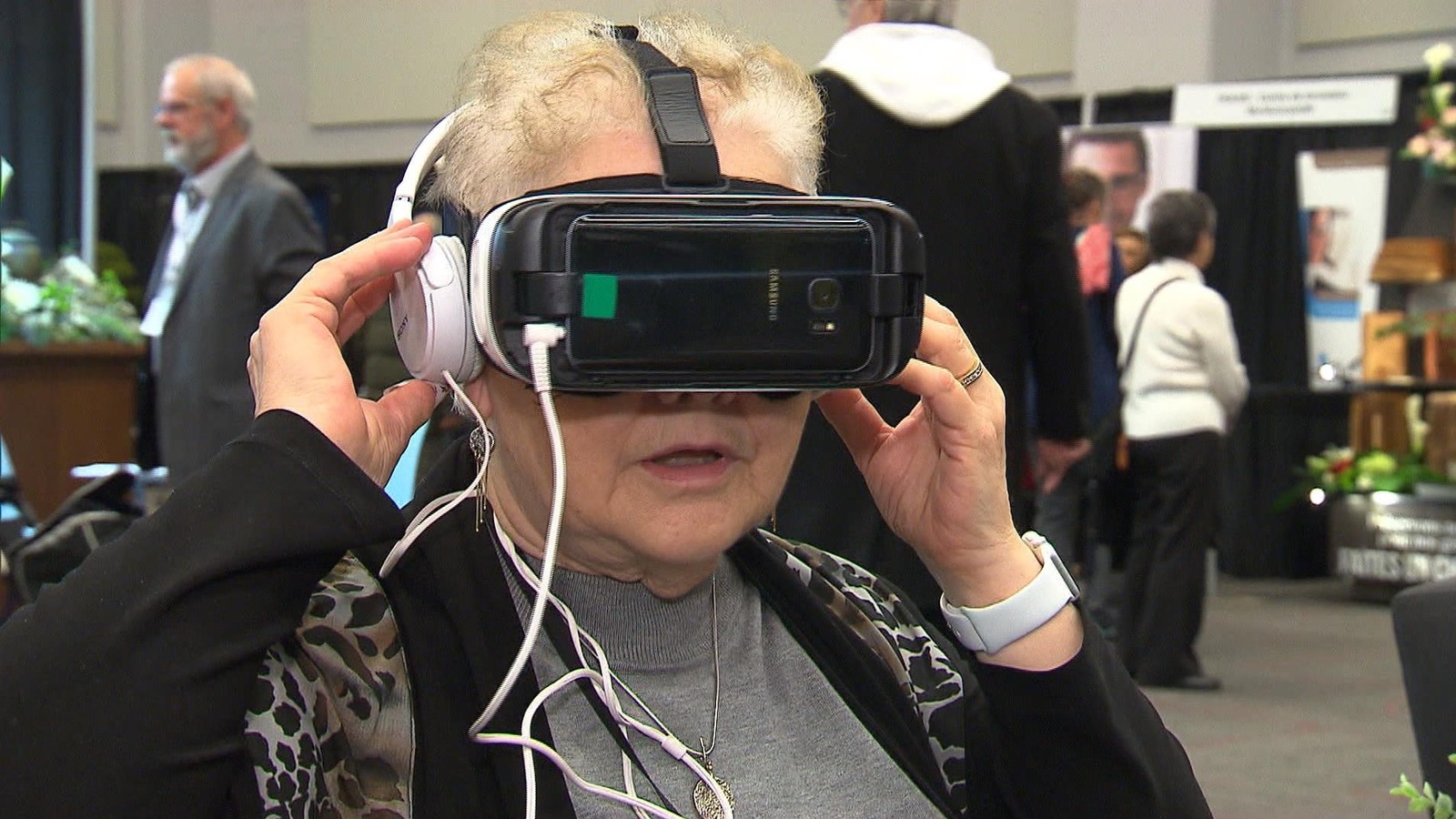 Une dame porte un casque de réalité virtuelle sur la tête, avec des écouteurs. Une dame porte un casque de réalité virtuelle sur la tête, avec des écouteurs.