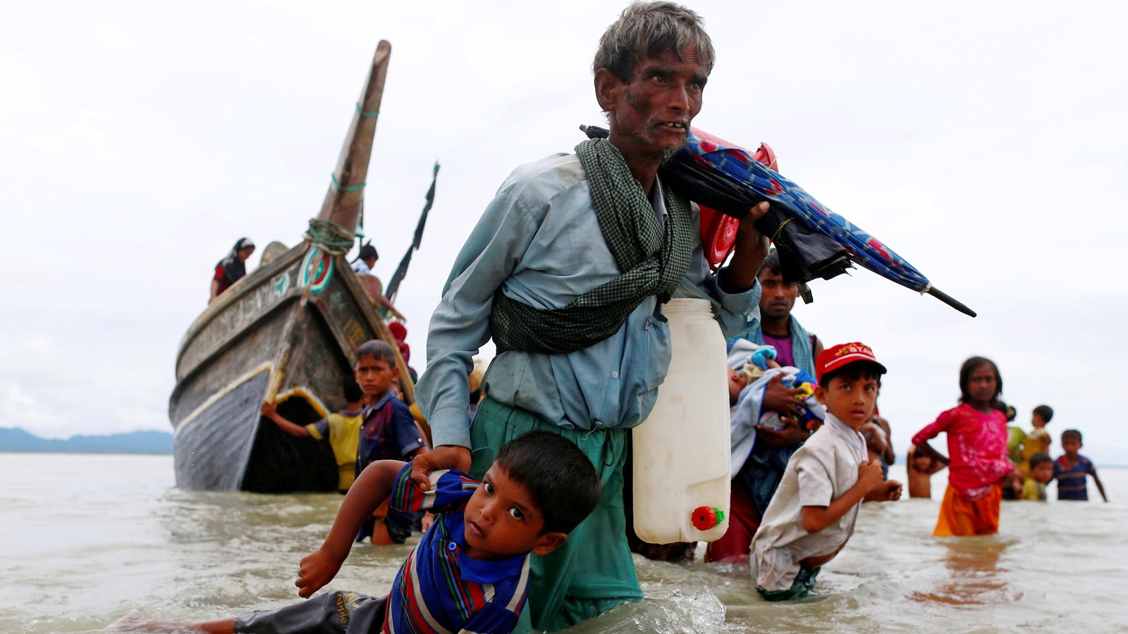Ce Rohingya traîne un garçon dans l'eau après avoir réussi à franchir la frontière entre le Myanmar et le Bangladesh. Ce Rohingya traîne un garçon dans l'eau après avoir réussi à franchir la frontière entre le Myanmar et le Bangladesh.
