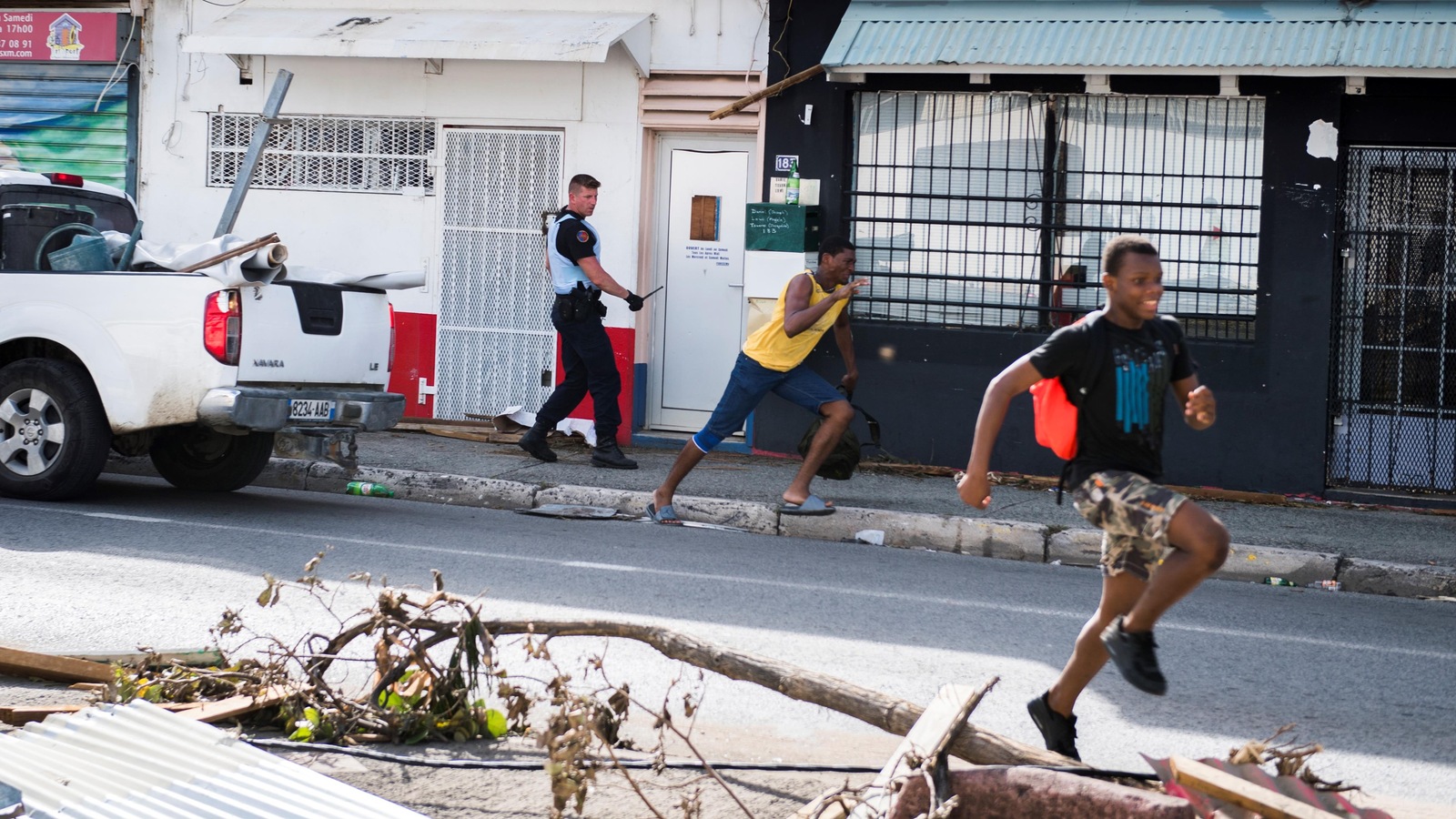 Un soldat de la gendarmerie française chasse deux jeunes pilleurs près de Marigot, sur l'île de Saint-Martin. Un soldat de la gendarmerie française chasse deux jeunes pilleurs près de Marigot, sur l'île de Saint-Martin.