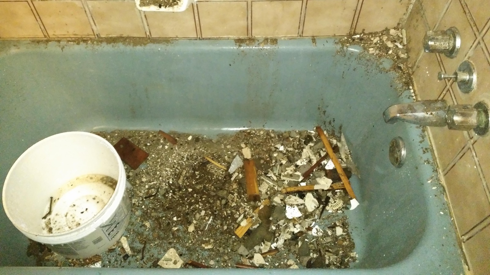 Une douche insalubre avec les débris du plafond qui s'est effondré au fond du bain. Une douche insalubre avec les débris du plafond qui s'est effondré au fond du bain.