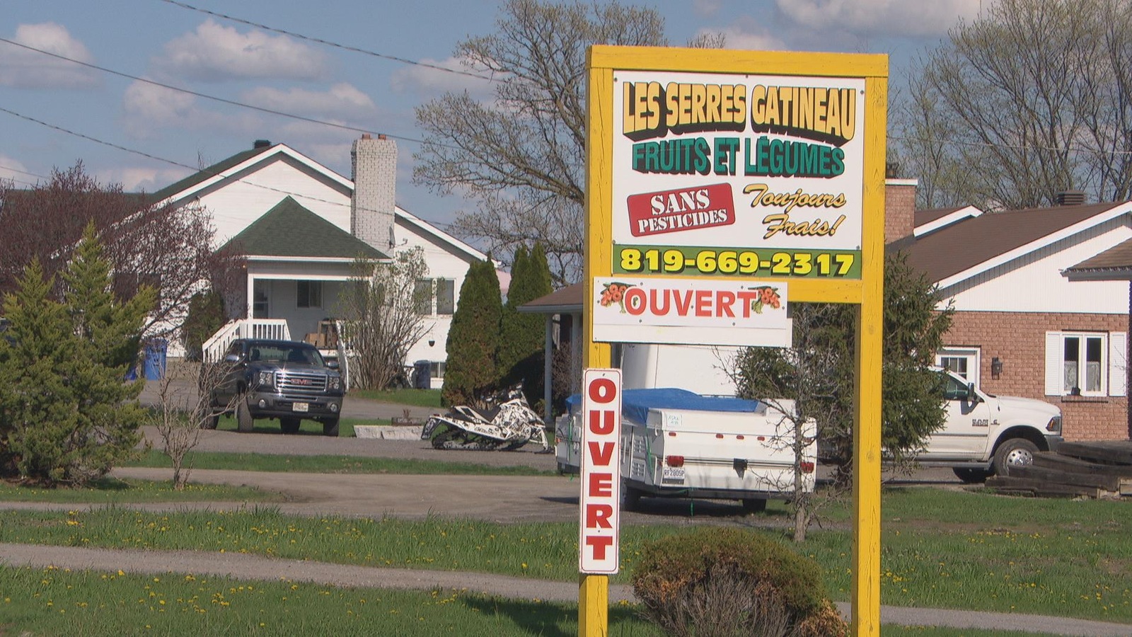 Sur une pelouse, un panneau des Serres Gatineau. Sur une pelouse, un panneau des Serres Gatineau.