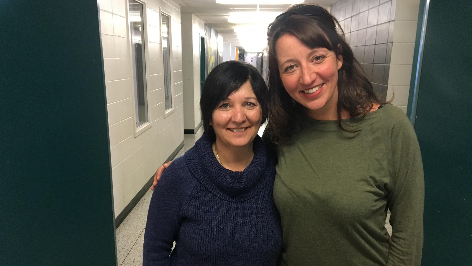 Deux femmes sourient pour la caméra dans un couloir d'école secondaire, bras dessus, bras dessous. Deux femmes sourient pour la caméra dans un couloir d'école secondaire, bras dessus, bras dessous.