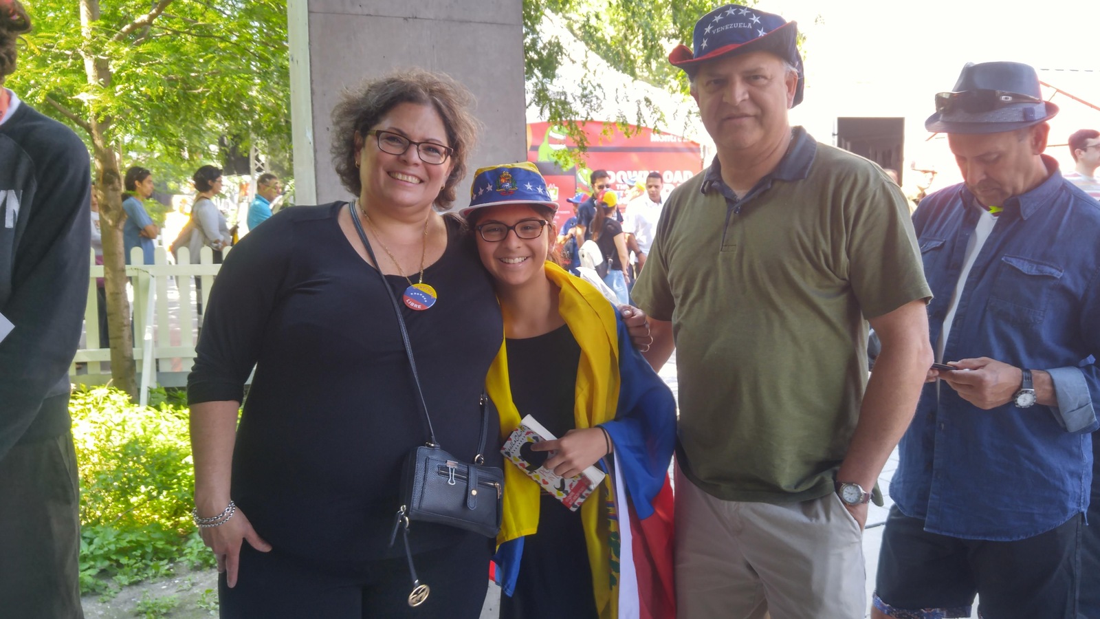 Une jeune fille porte le drapeau du Venezuela sur ses épaules, entourée de ses parents. Une jeune fille porte le drapeau du Venezuela sur ses épaules, entourée de ses parents.