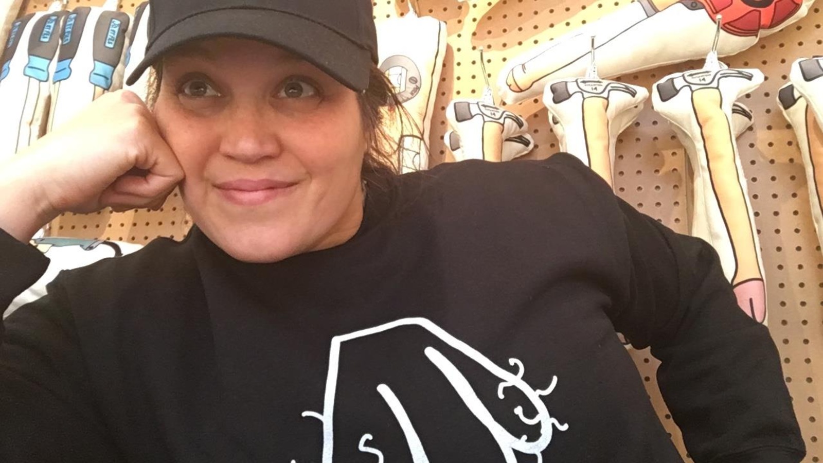 Jolène Morin avec une casquette noire et un coton ouaté orné d'un dessin d'organe masculin, devant sa quincaillerie de pénis. Jolène Morin avec une casquette noire et un coton ouaté orné d'un dessin d'organe masculin, devant sa quincaillerie de pénis.