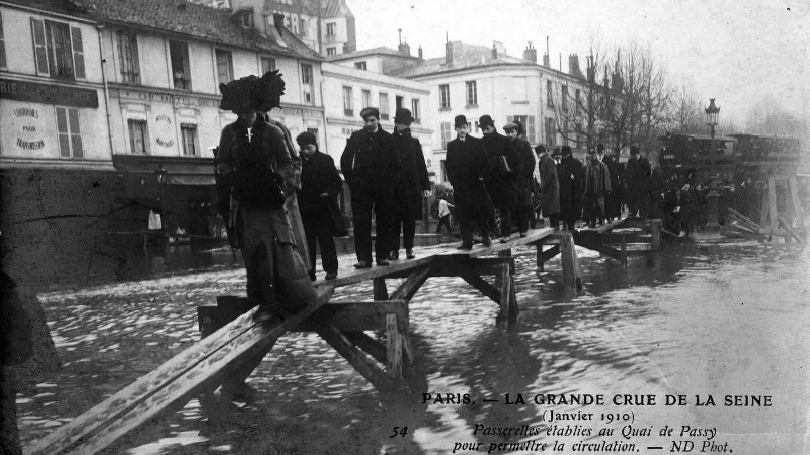 Photo en noir et blanc de piétons qui traversent la Seine sur un pont de fortune. Photo en noir et blanc de piétons qui traversent la Seine sur un pont de fortune.