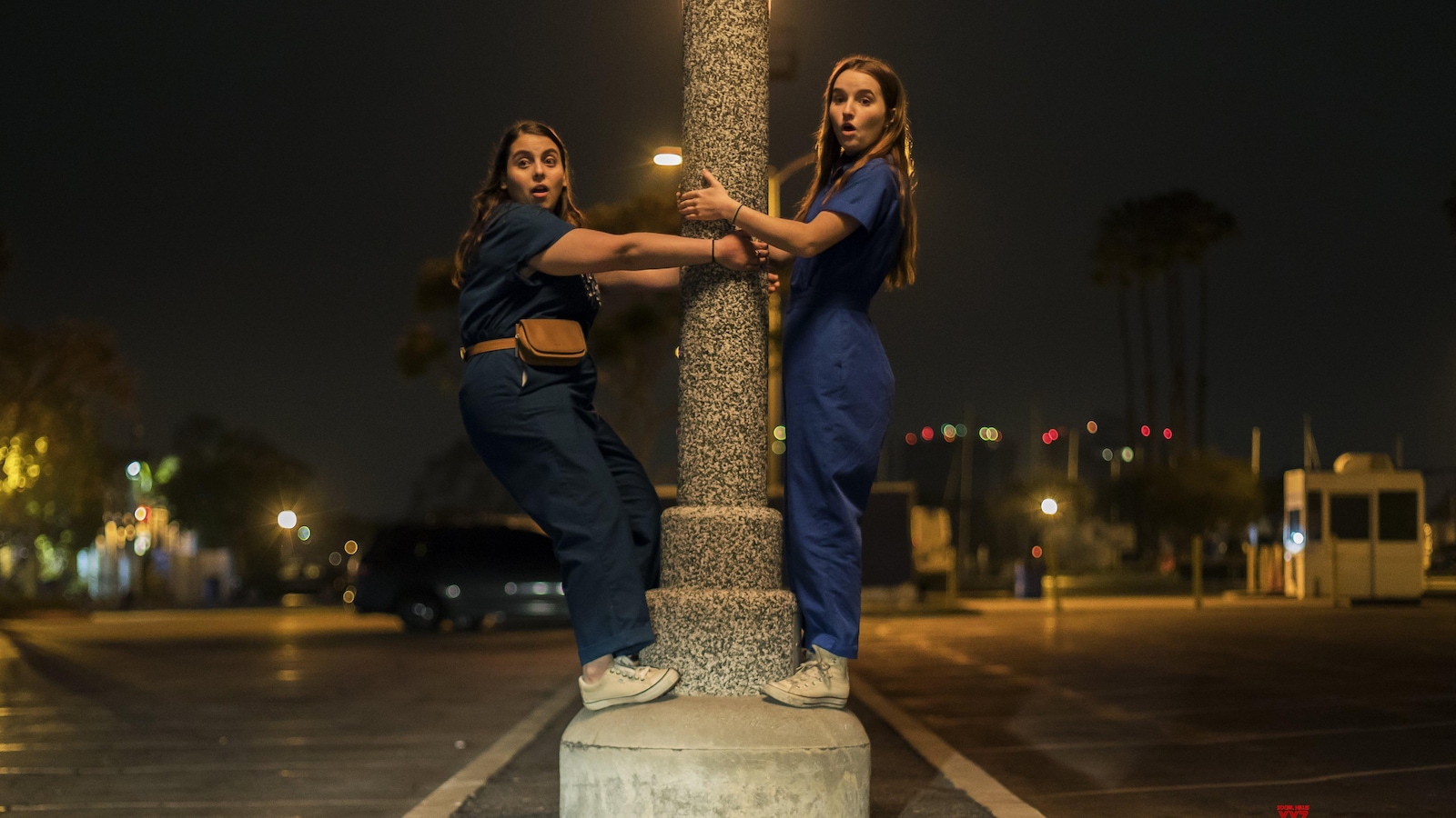 Deux jeunes filles s'accrochent à un lampadaire. Deux jeunes filles s'accrochent à un lampadaire.