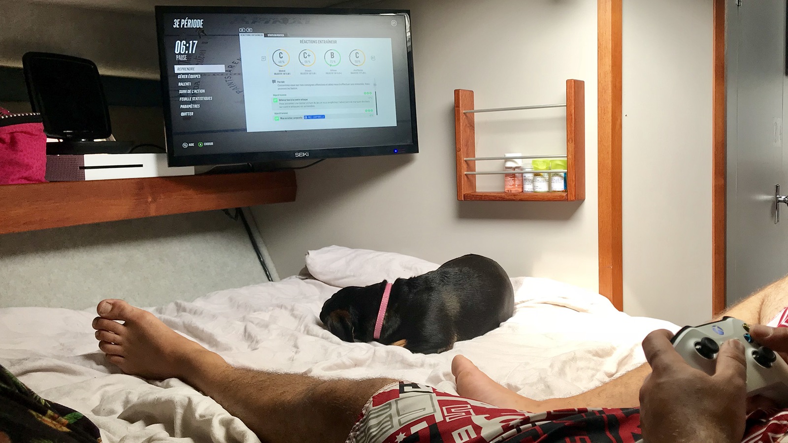 Un homme assis sur un lit joue à un jeu vidéo Un homme assis sur un lit joue à un jeu vidéo