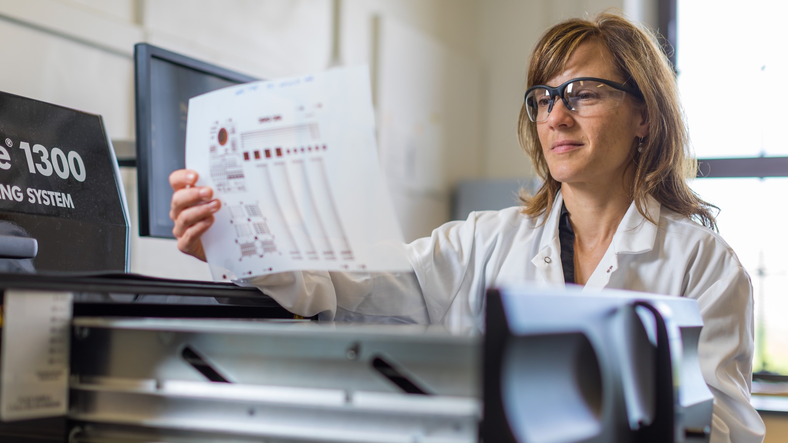 Chantel Paquet regarde une feuille de papier où des composantes électroniques ont été imprimées. Chantel Paquet regarde une feuille de papier où des composantes électroniques ont été imprimées.