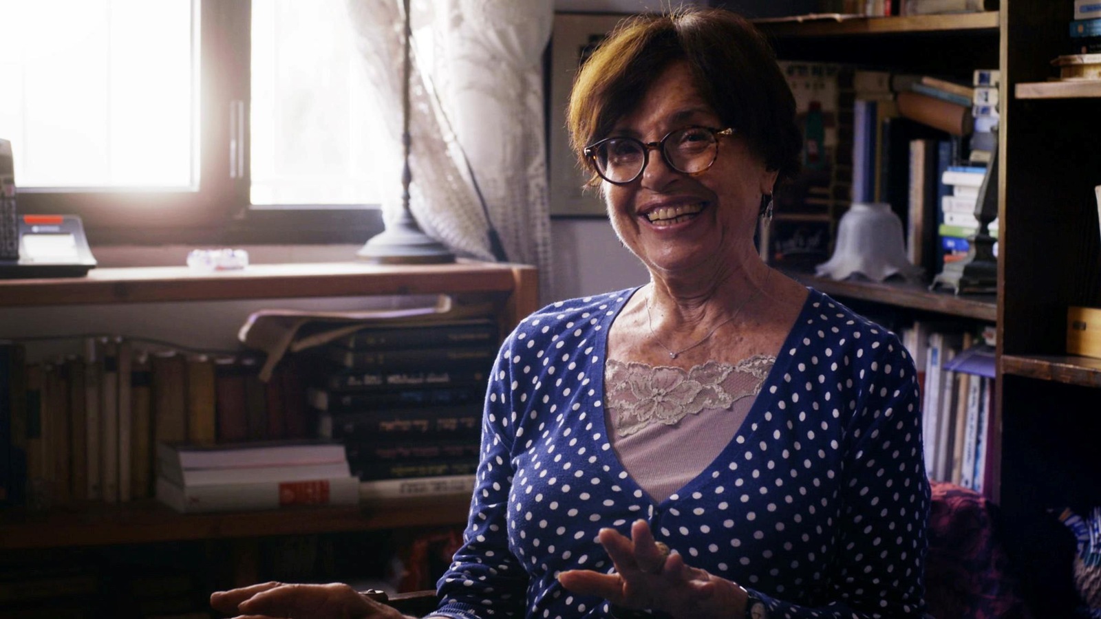 Ziva Postec dans un bureau heureuse avec des bibliothèques de tout les cotés Ziva Postec dans un bureau heureuse avec des bibliothèques de tout les cotés