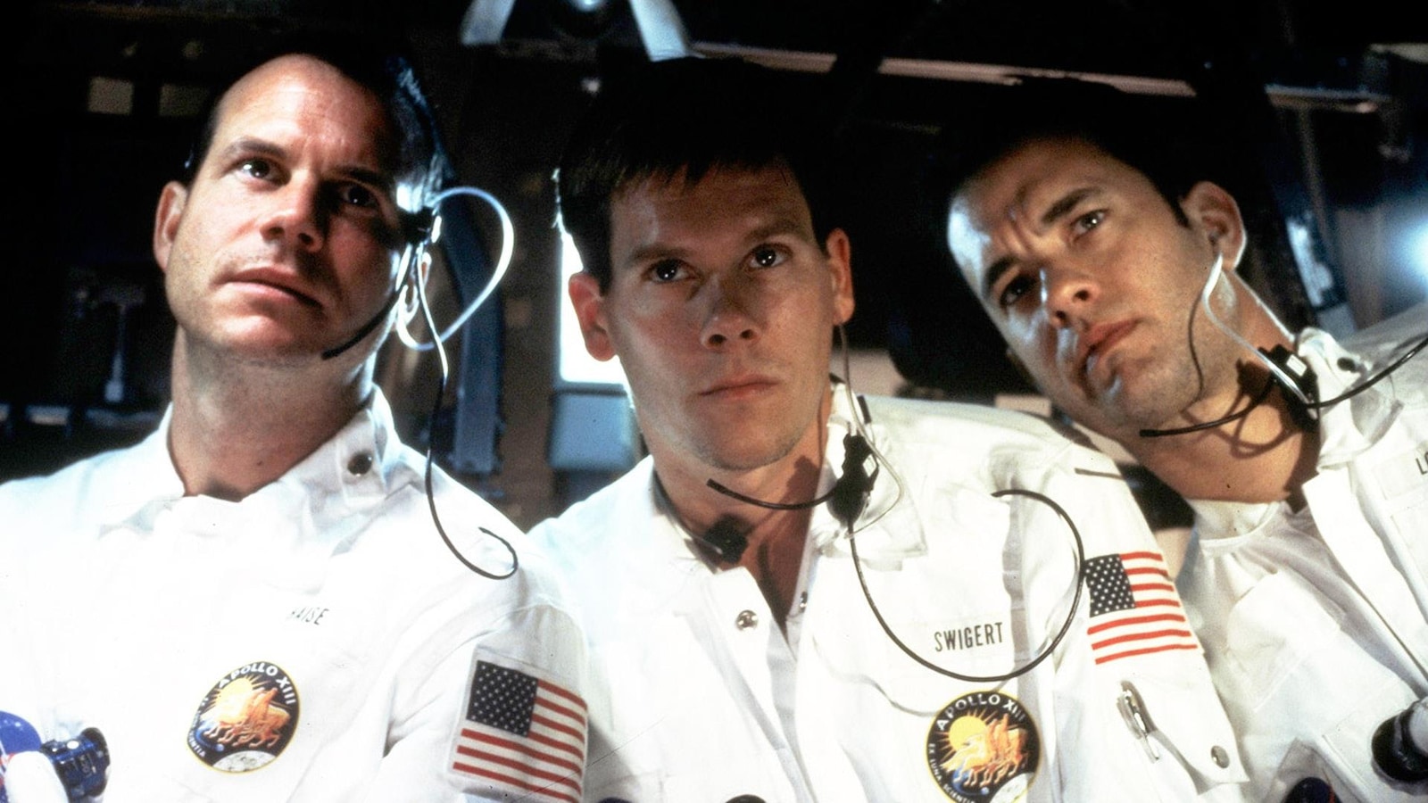 Trois hommes vêtus d'uniformes blancs dans une navette spatiale. Trois hommes vêtus d'uniformes blancs dans une navette spatiale.