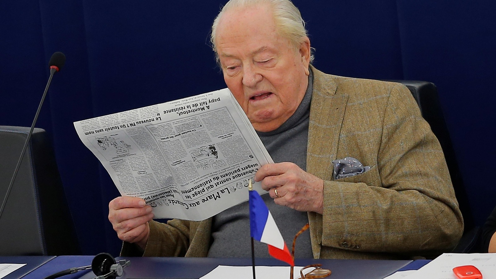 Jean-Marie Le Pen lit un exemplaire du <i>Canard enchaîné</i> durant une session du Parlement européen. Jean-Marie Le Pen lit un exemplaire du <i>Canard enchaîné</i> durant une session du Parlement européen.