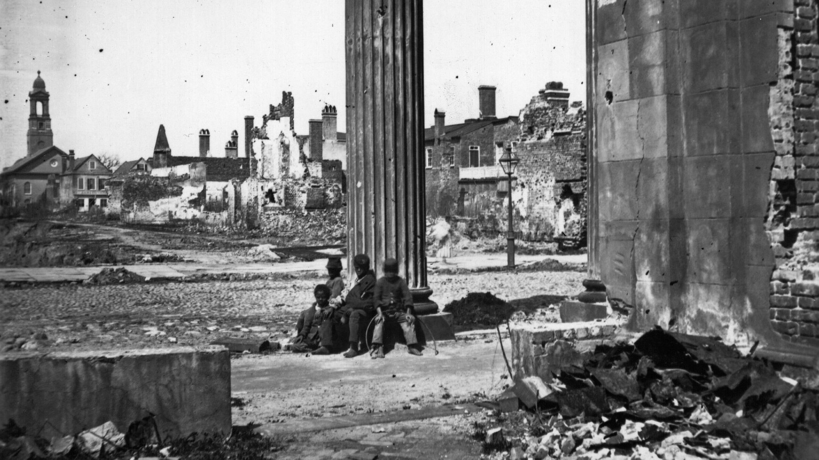 Des enfants noirs sont assis dans les ruines de la ville de Charleston, en Caroline du Sud. Des enfants noirs sont assis dans les ruines de la ville de Charleston, en Caroline du Sud.