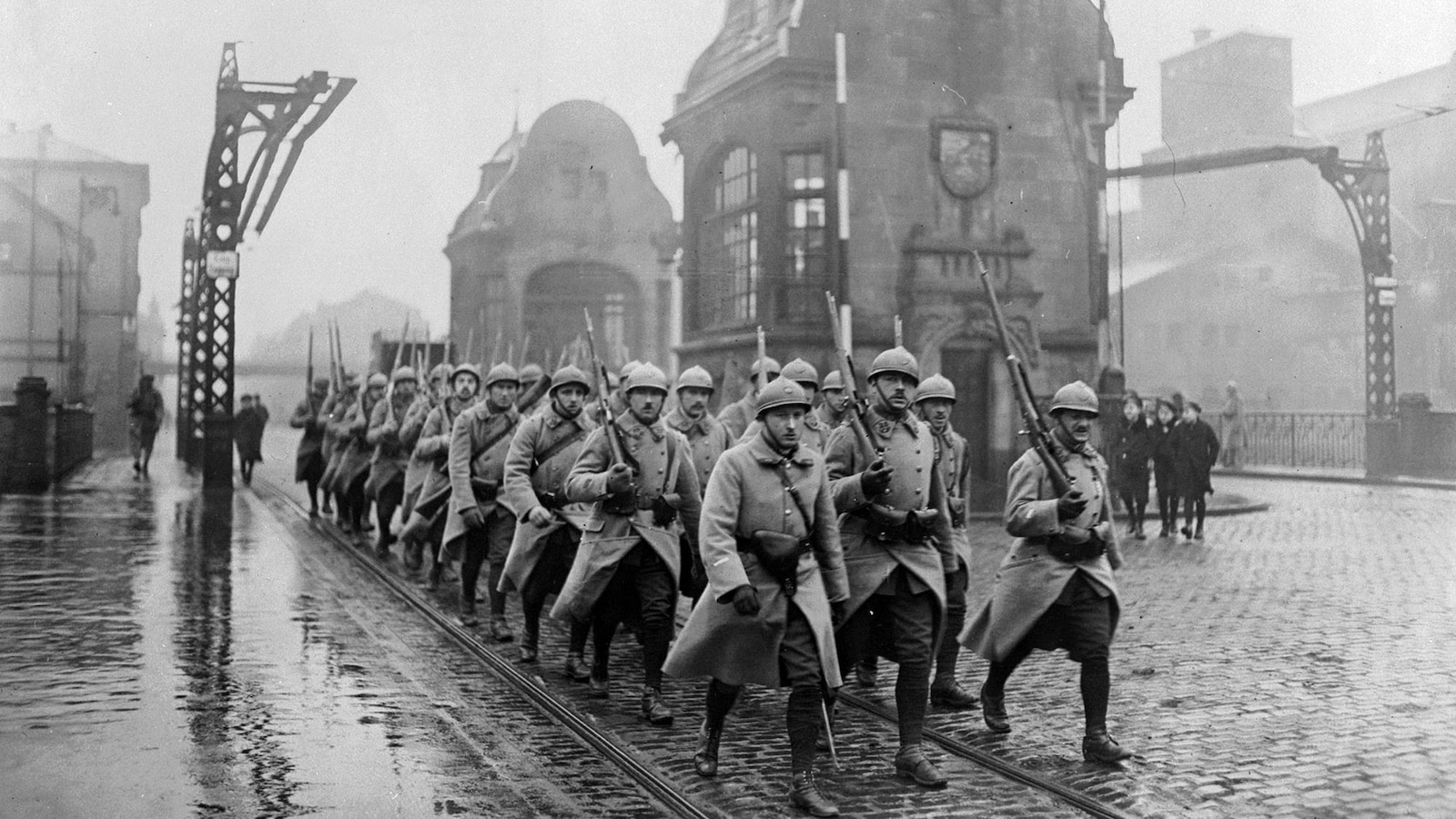 Photo en noir et blanc d'un groupe de soldats marchant dans une rue. Photo en noir et blanc d'un groupe de soldats marchant dans une rue.
