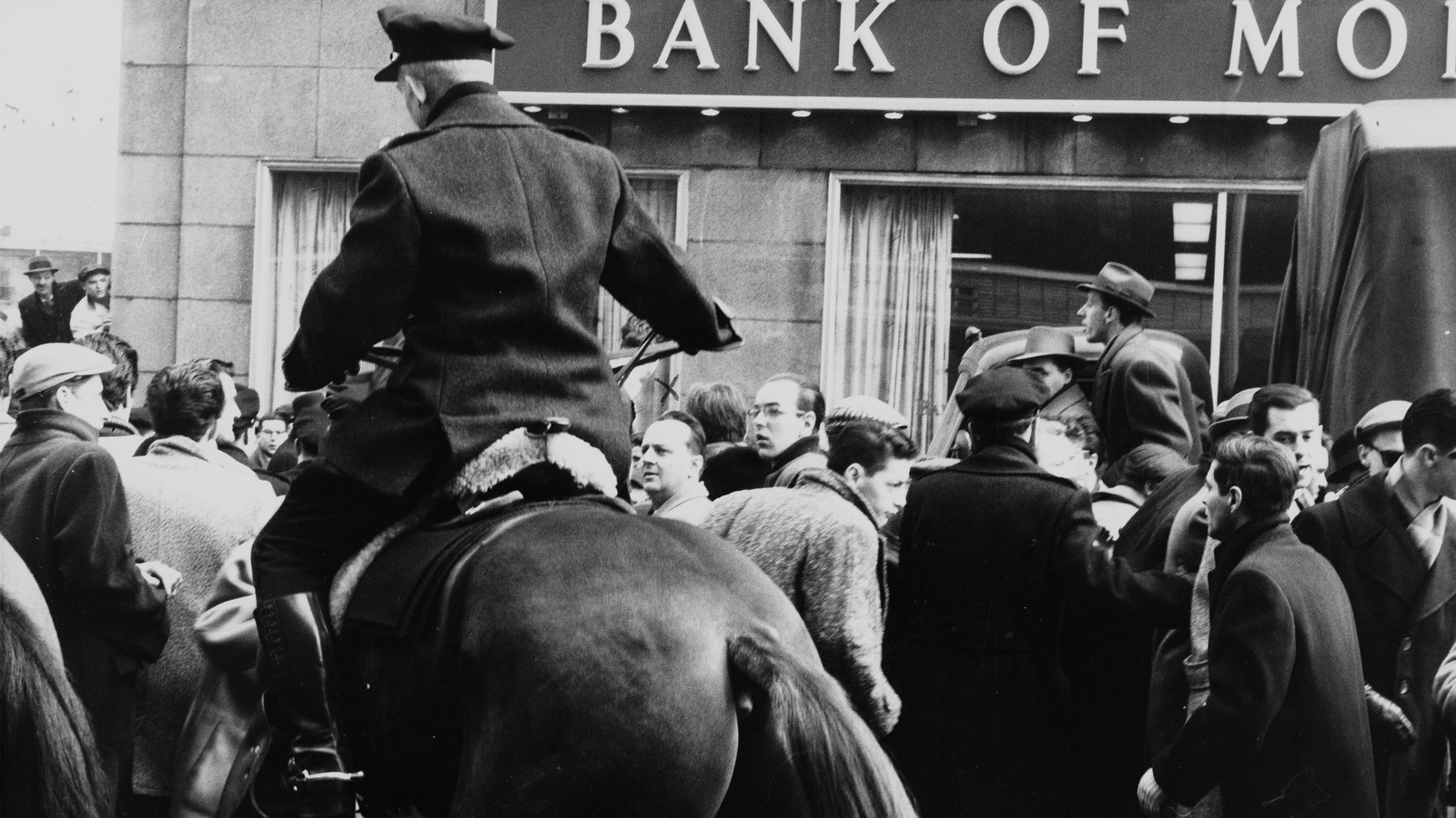 Un policier à cheval et des grévistes devant un édifice de la banque de Montréal. Un policier à cheval et des grévistes devant un édifice de la banque de Montréal.