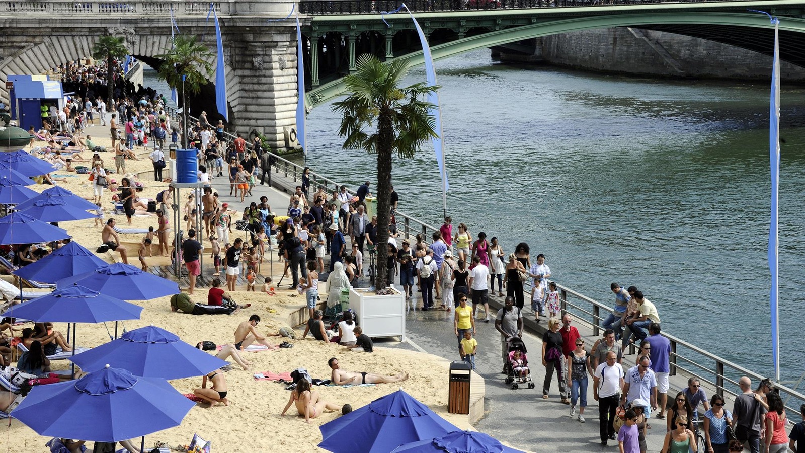 Des personnes sont sur une plage sur les berges d'un fleuve. Des personnes sont sur une plage sur les berges d'un fleuve.