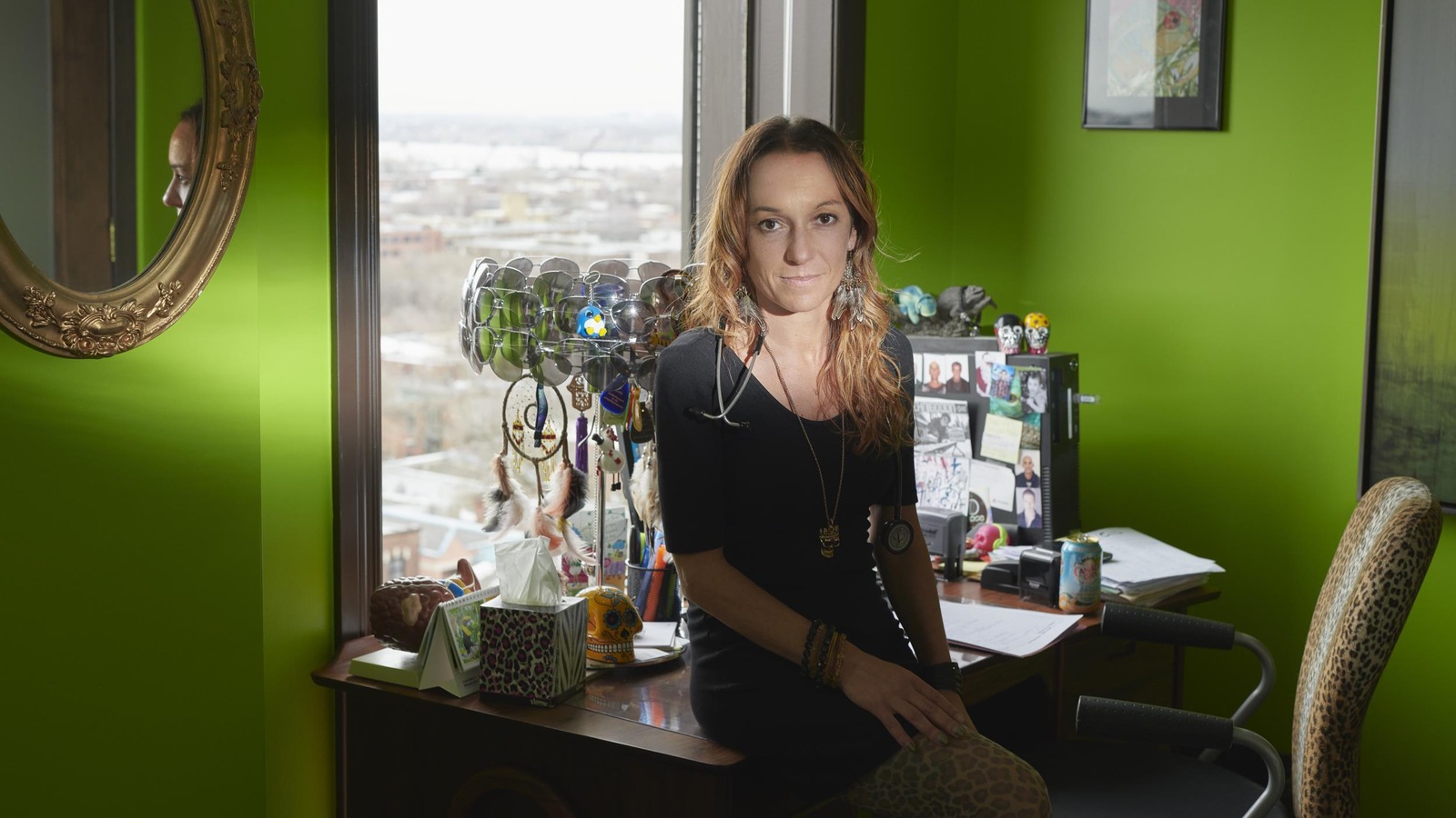 Elle est assise sur son bureau devant une fenêtre. Elle est assise sur son bureau devant une fenêtre.
