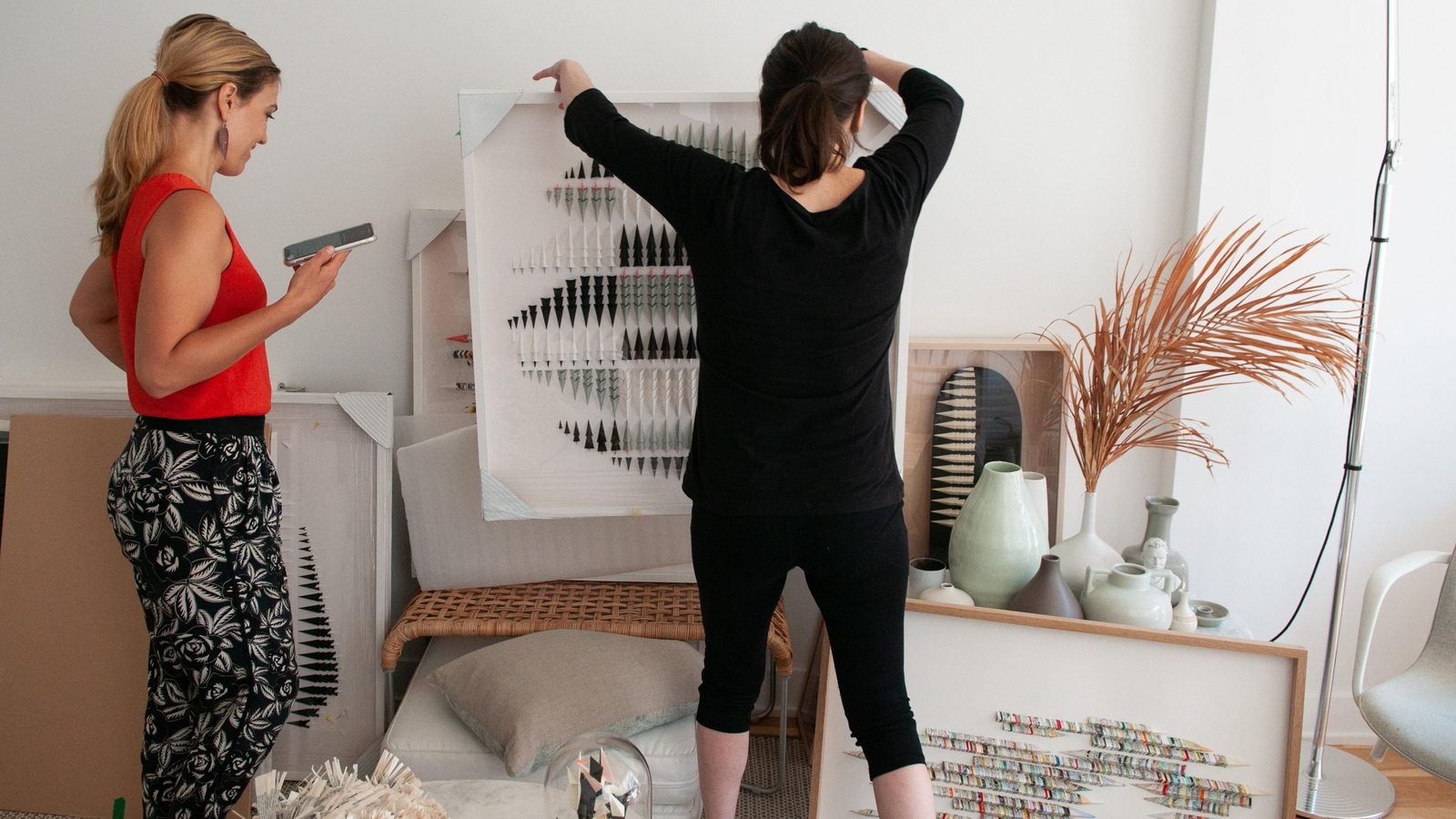 Deux femmes transportent des œuvres d'art dans un atelier blanc. Deux femmes transportent des œuvres d'art dans un atelier blanc.