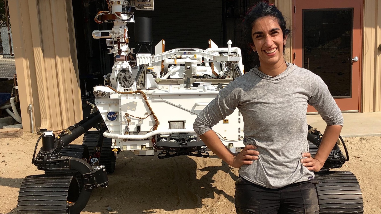 Farah Alibay sourit au moment de se faire prendre en photo devant le robot Perseverance. Farah Alibay sourit au moment de se faire prendre en photo devant le robot Perseverance.
