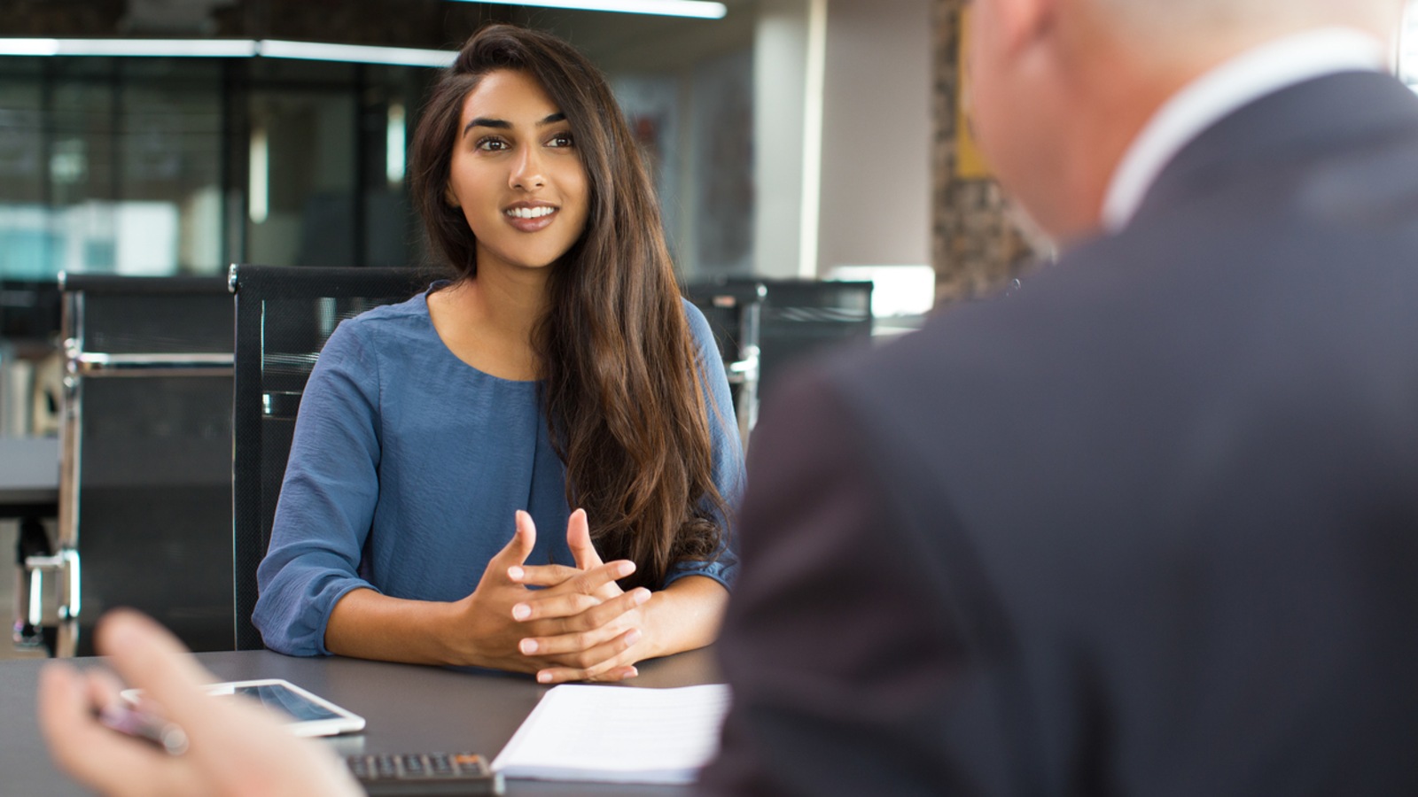 Une femme et un homme assis à un bureau lors d'une entrevue d'emploi. Une femme et un homme assis à un bureau lors d'une entrevue d'emploi.