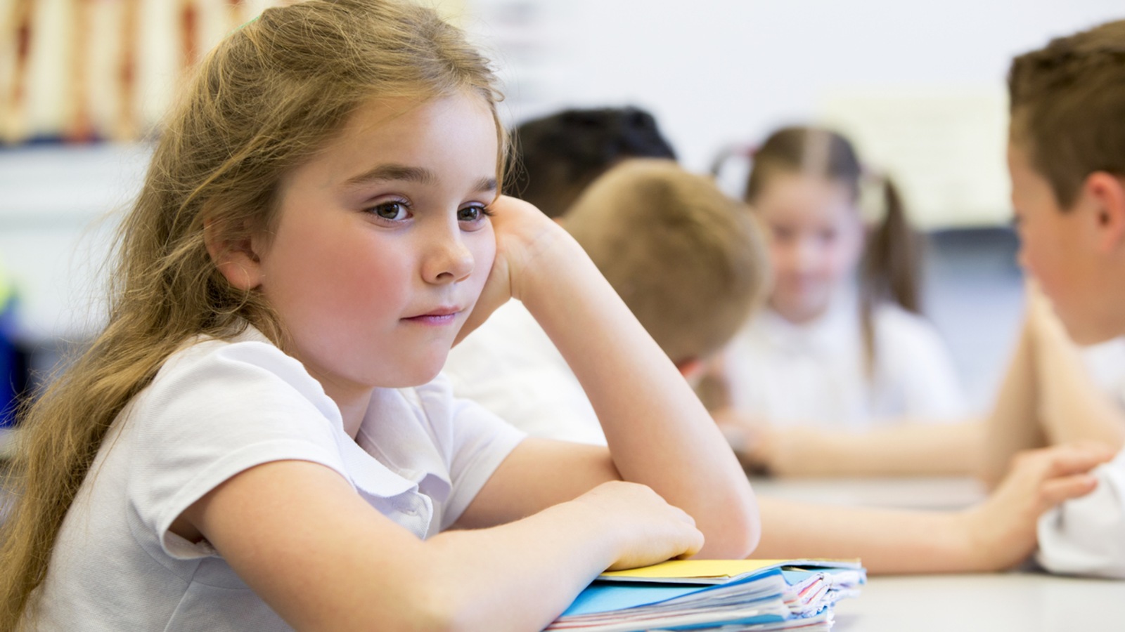 Une jeune écolière qui semble s'ennuyer à son pupitre, à l'école. Une jeune écolière qui semble s'ennuyer à son pupitre, à l'école.