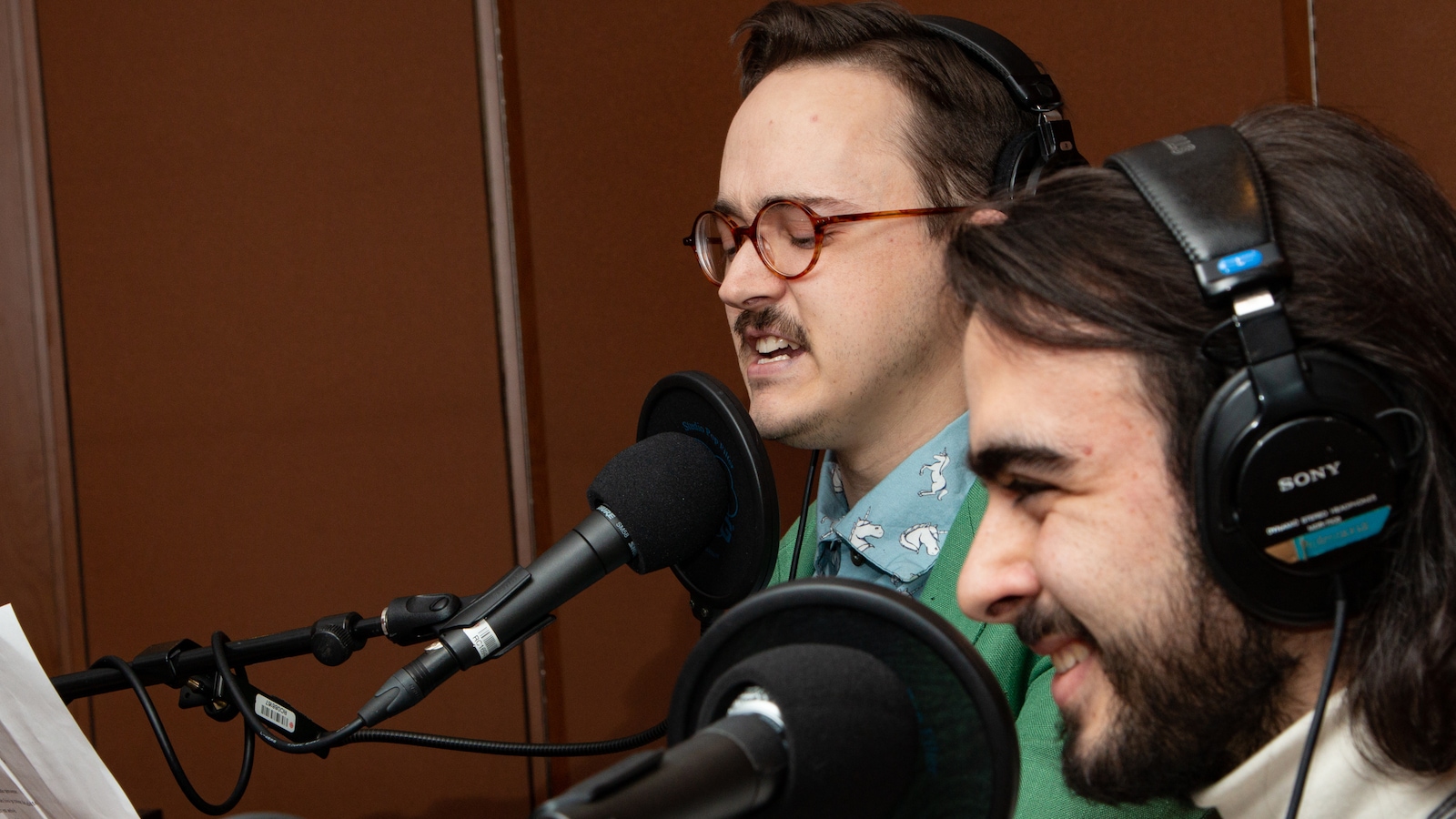 Les deux jeunes hommes sourient devant leur texte. Les deux jeunes hommes sourient devant leur texte.