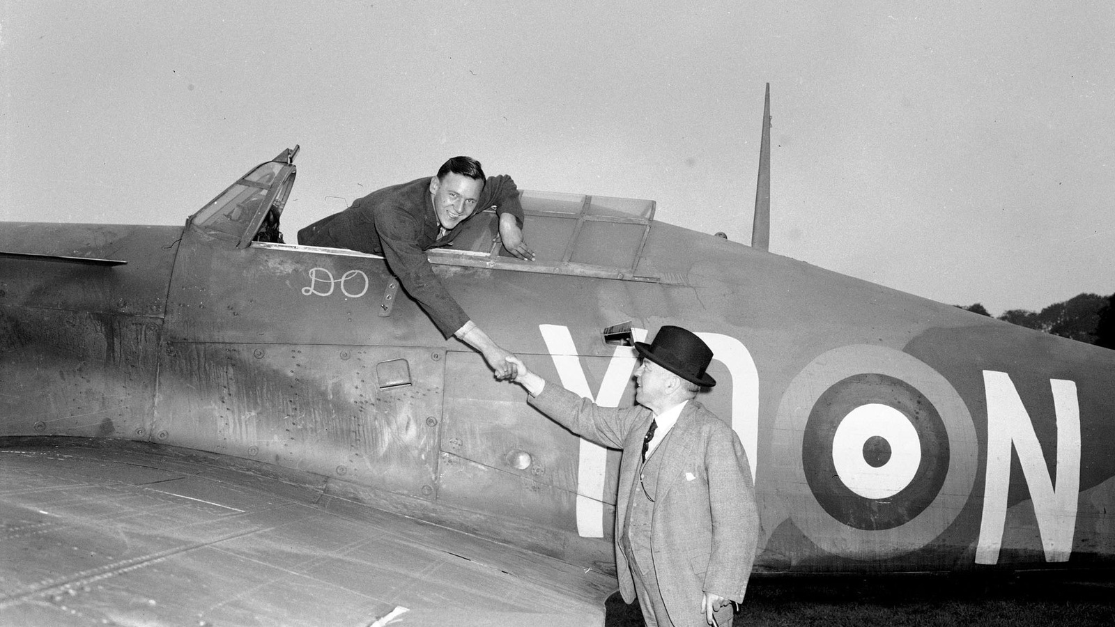 Deux hommes serrent la main. L'un est au sol, l'autre est dans un avion de chasse. Deux hommes serrent la main. L'un est au sol, l'autre est dans un avion de chasse.