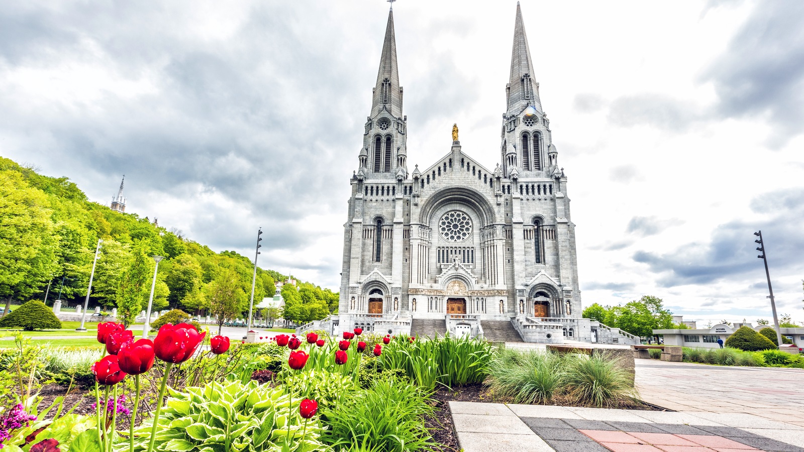 La basilique Sainte-Anne-de-Beaupré vue de l'extérieur, avec des tulipes rouges devant l'édifice. La basilique Sainte-Anne-de-Beaupré vue de l'extérieur, avec des tulipes rouges devant l'édifice.