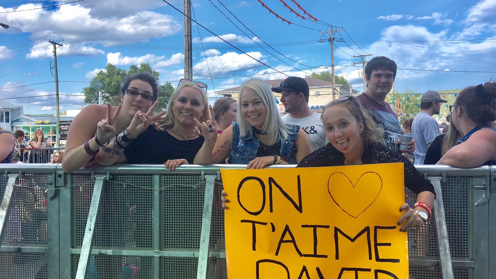 Elles tiennent une pancarte sur laquelle est écrit : "On t'aime David". Elles tiennent une pancarte sur laquelle est écrit : "On t'aime David".