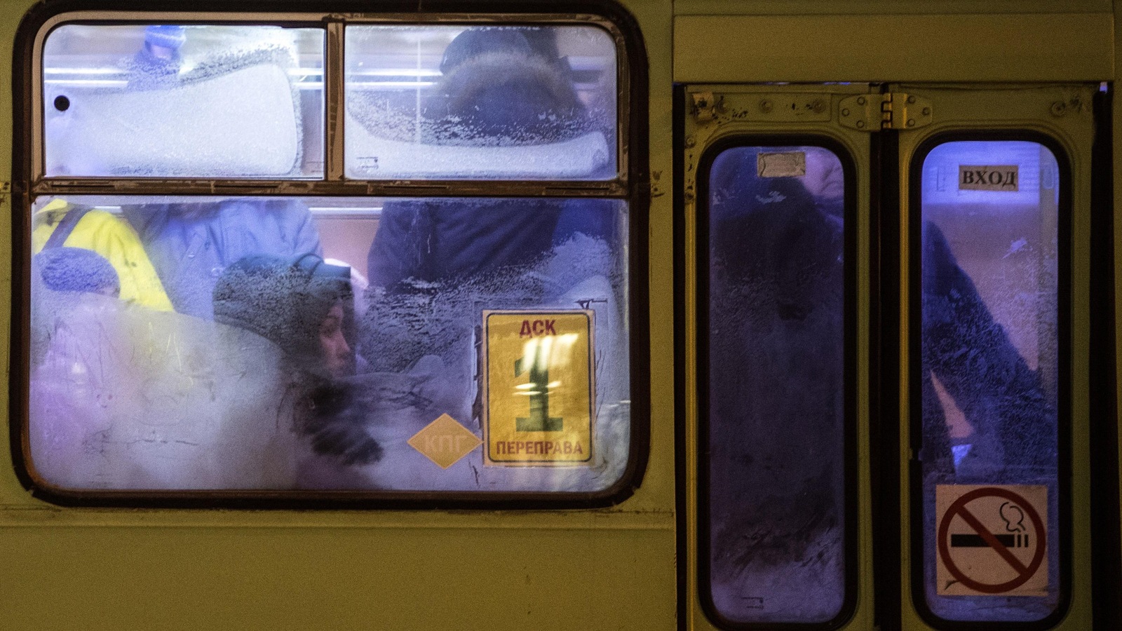 Des gens assis et debout en habits d'hiver dans un tramway. Des gens assis et debout en habits d'hiver dans un tramway.