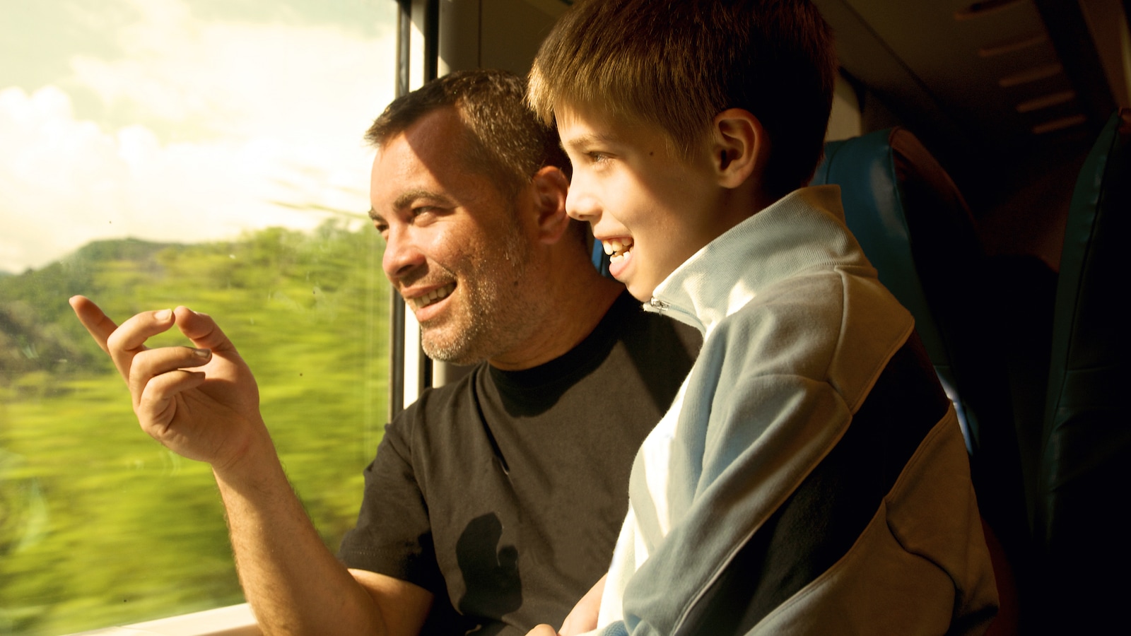 Un père et son fils dans un train sourient devant une fenêtre. Un père et son fils dans un train sourient devant une fenêtre.