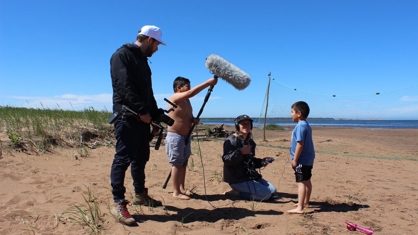 Équipe du Wapikoni mobile sur la plage à Nutashkuan avec deux enfants innus Équipe du Wapikoni mobile sur la plage à Nutashkuan avec deux enfants innus