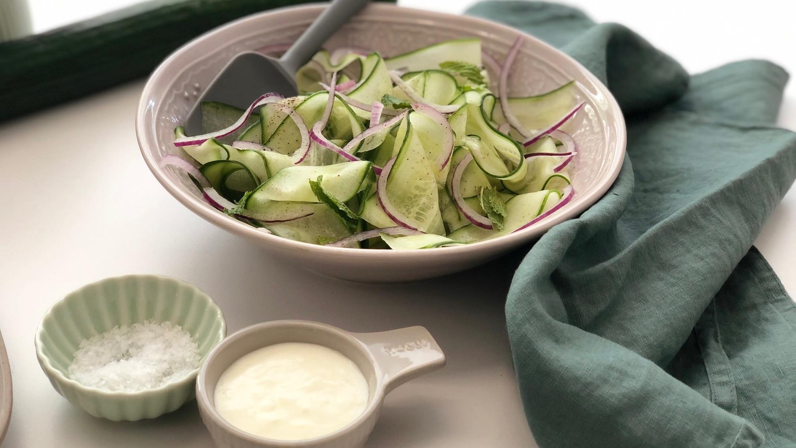 Un bol de salade de concombre en rubans avec un petit bol de vinaigrette à l'ail. Un bol de salade de concombre en rubans avec un petit bol de vinaigrette à l'ail.