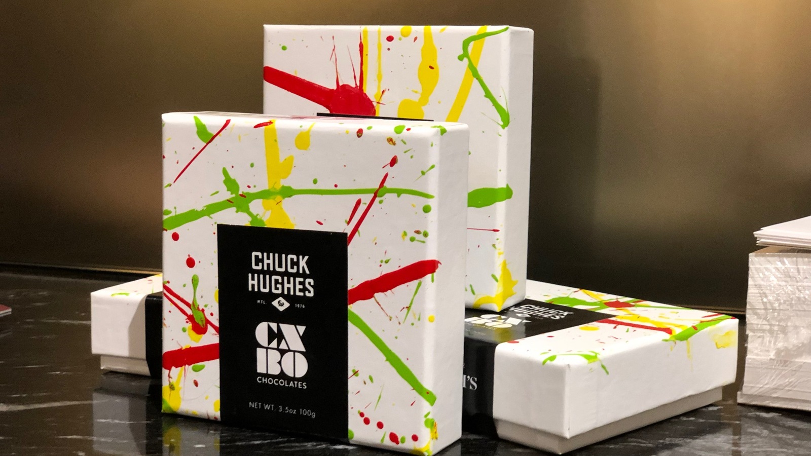Des boîtes de chocolats de CXBO avec des lignes vertes, rouges et jaunes. Des boîtes de chocolats de CXBO avec des lignes vertes, rouges et jaunes.