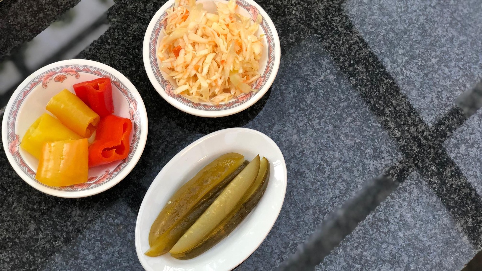 Un bol de poivrons marinés, des cornichons et de la salade de chou. Un bol de poivrons marinés, des cornichons et de la salade de chou.