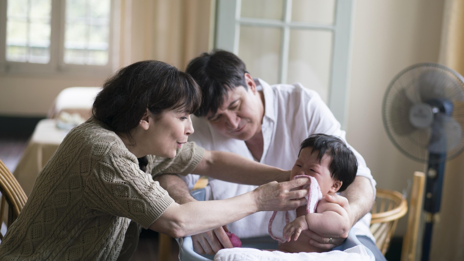 Un couple (Anne Dorval et François Papineau) lavent un bébé. Un couple (Anne Dorval et François Papineau) lavent un bébé.