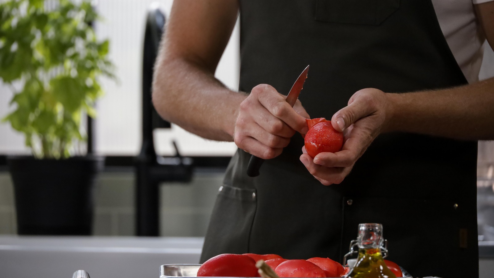 Le chef tient un couteau et une tomate. Le chef tient un couteau et une tomate.