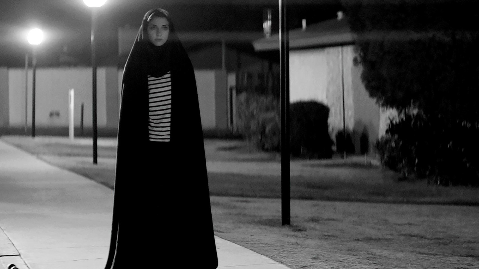 Une jeune fille voilée marche la nuit en noir et blanc Une jeune fille voilée marche la nuit en noir et blanc