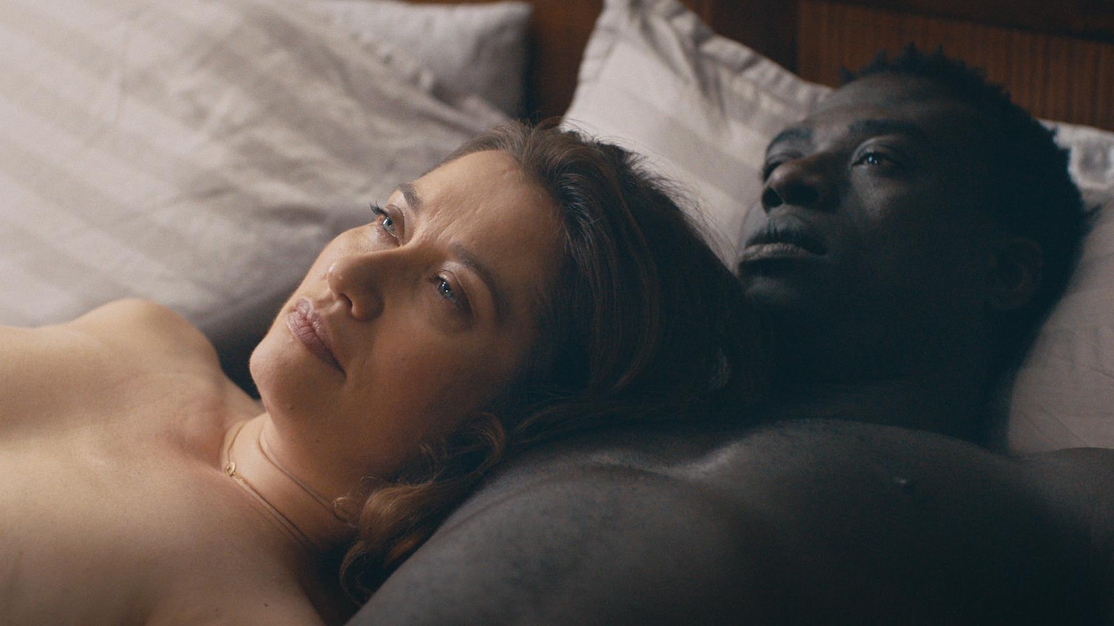 Une femme et un homme, nus, dans un lit, couchés sur le dos. Une femme et un homme, nus, dans un lit, couchés sur le dos.
