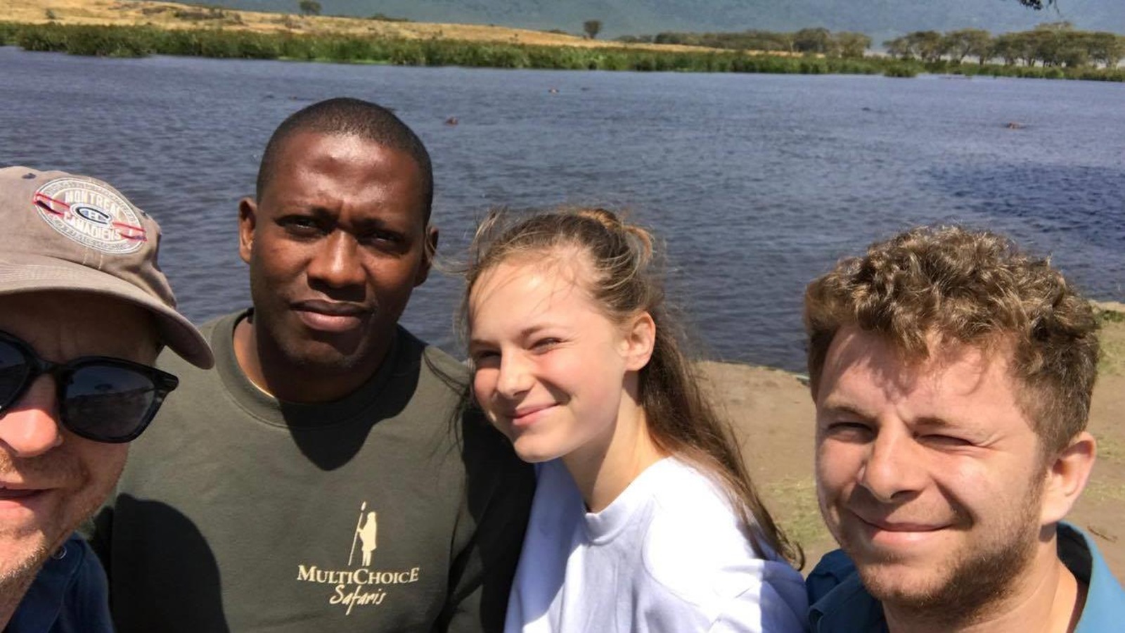 La famille est accompagnée par un guide, devant un lac La famille est accompagnée par un guide, devant un lac