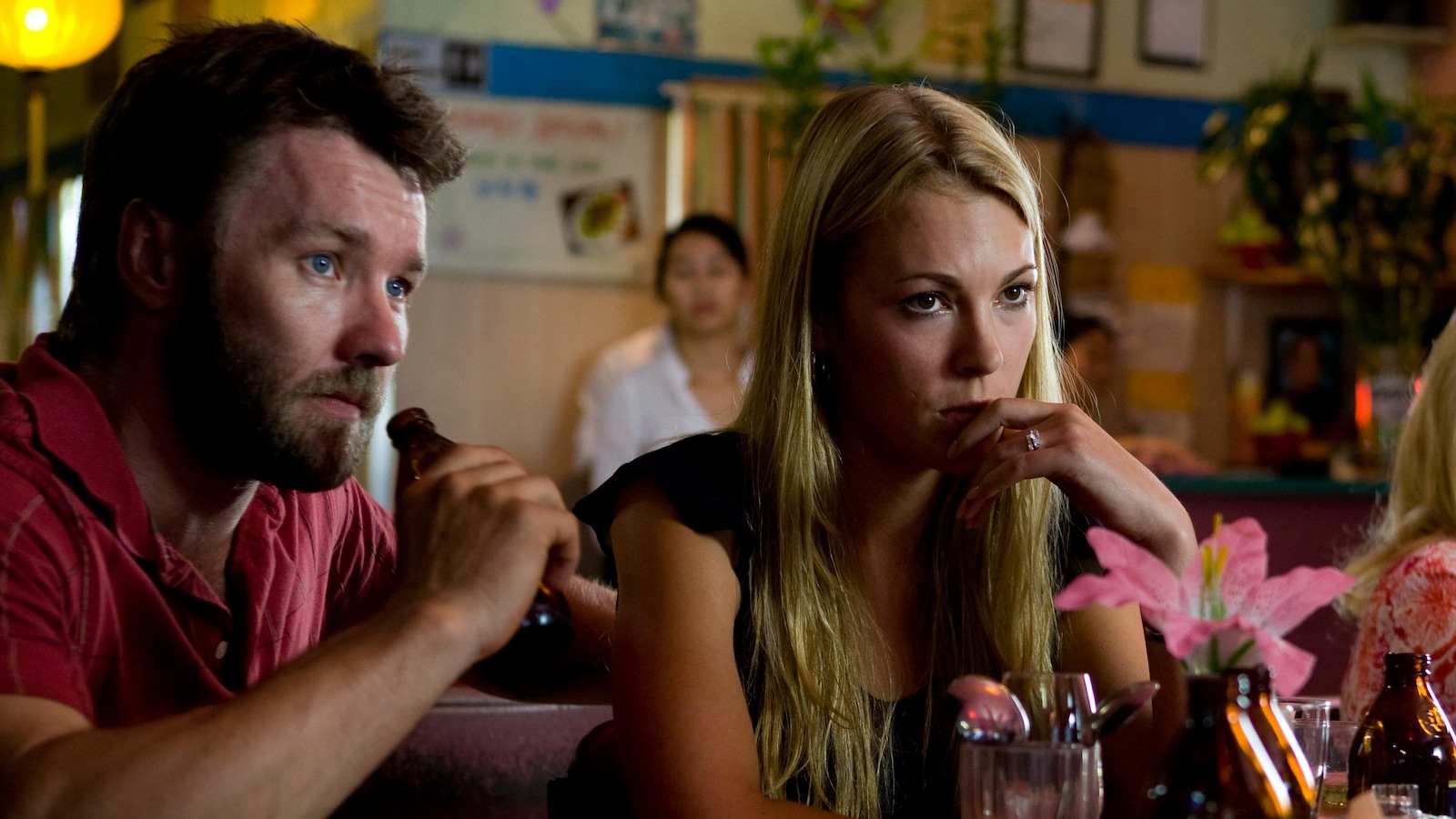 Un homme et une femme assis dans un restaurant côte à côte Un homme et une femme assis dans un restaurant côte à côte