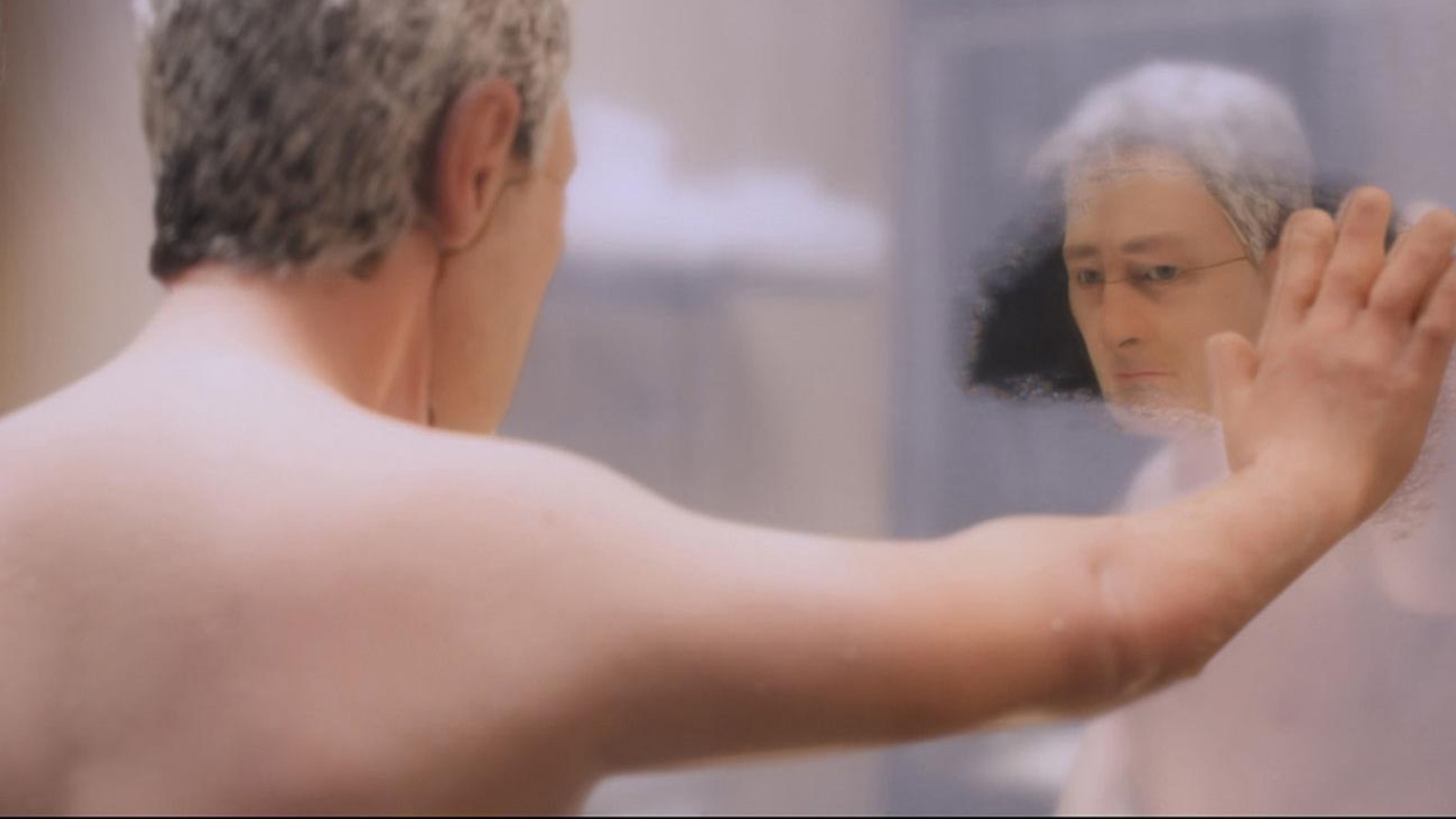 Un homme, en marionnette, essuie la buée dans un miroir devant lui. Un homme, en marionnette, essuie la buée dans un miroir devant lui.
