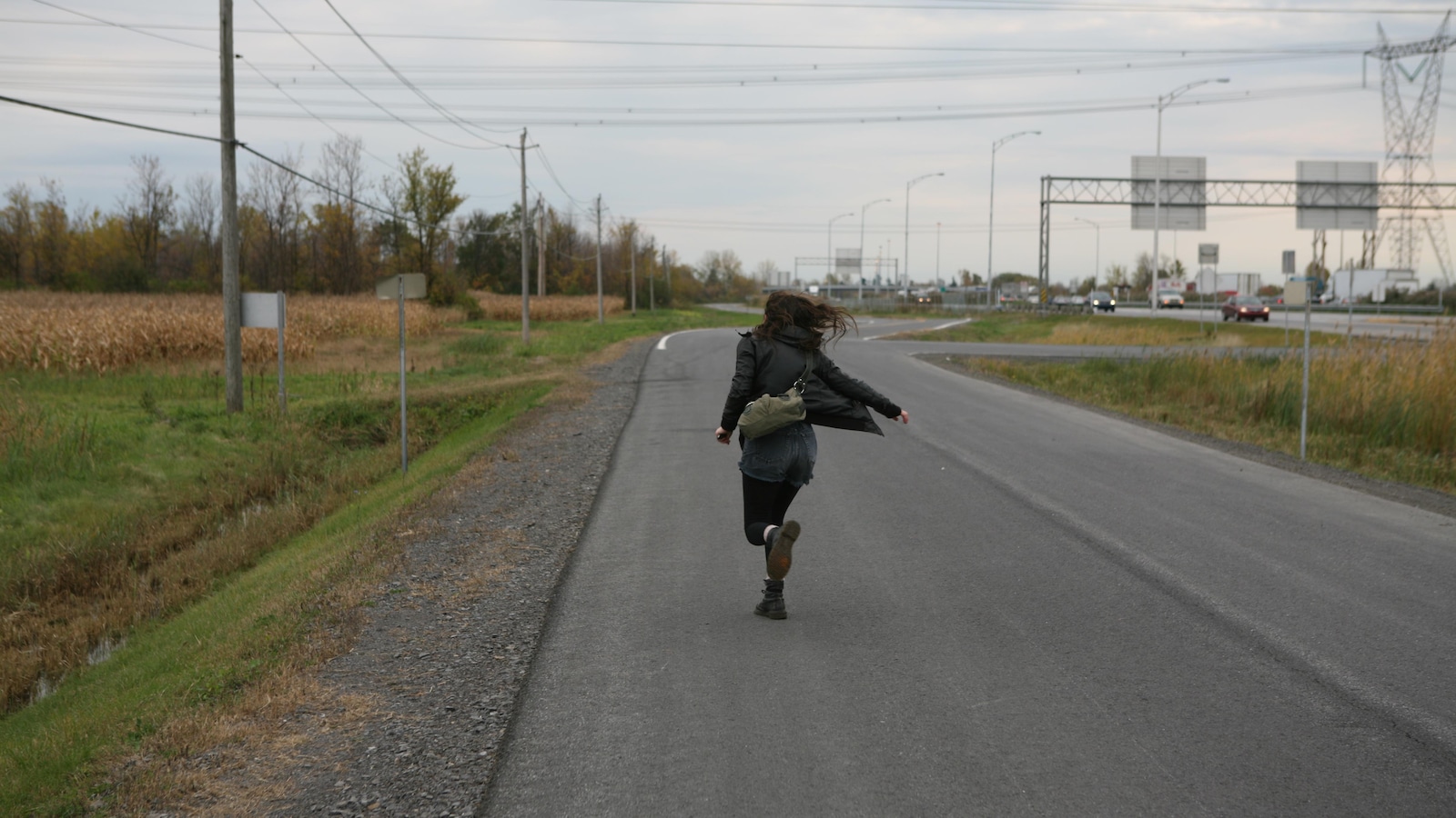 Une jeune fille, de dos, court sur une route. Une jeune fille, de dos, court sur une route.