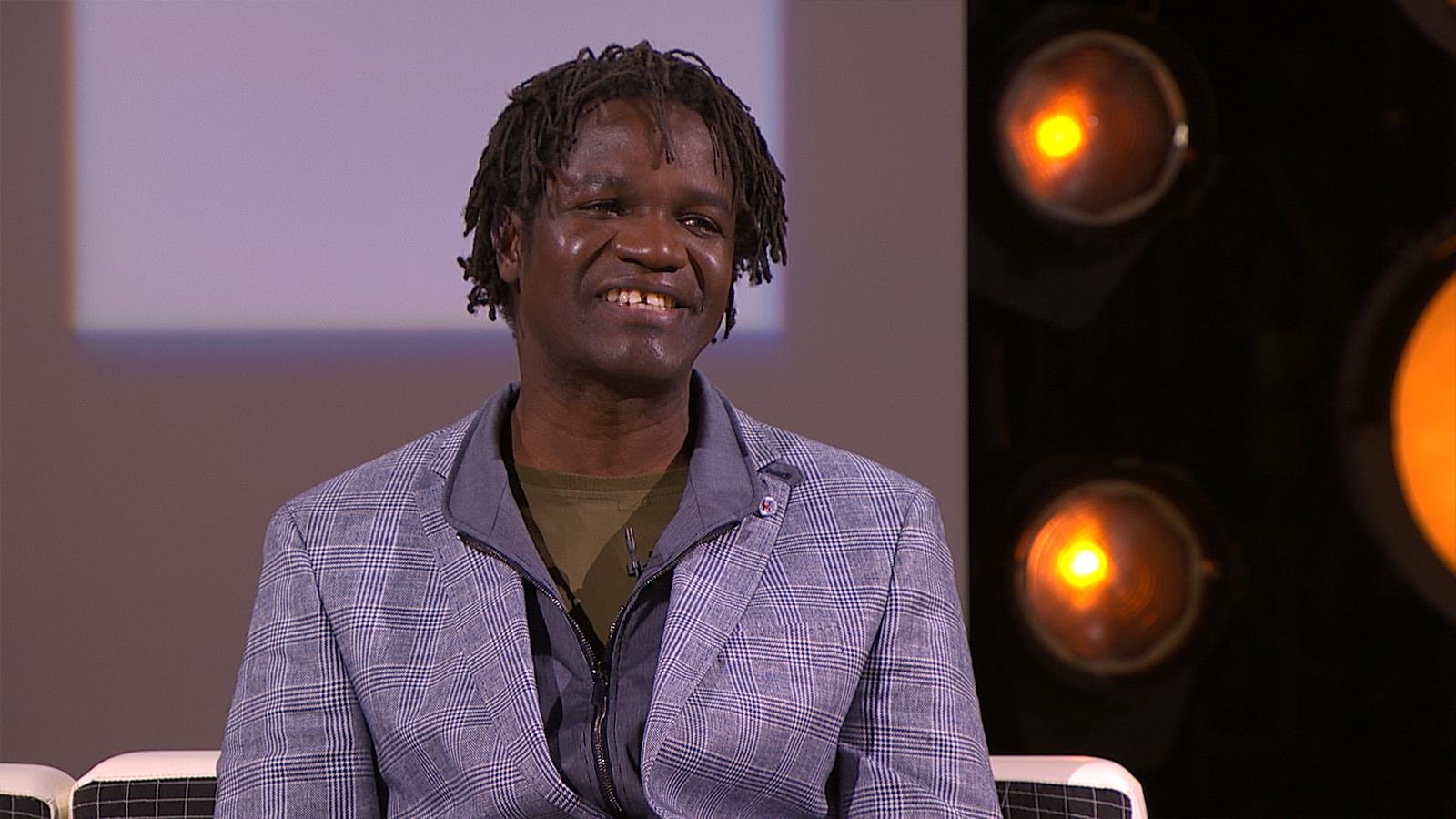 L'homme est assis dans un studio de télévision et il sourit. L'homme est assis dans un studio de télévision et il sourit.