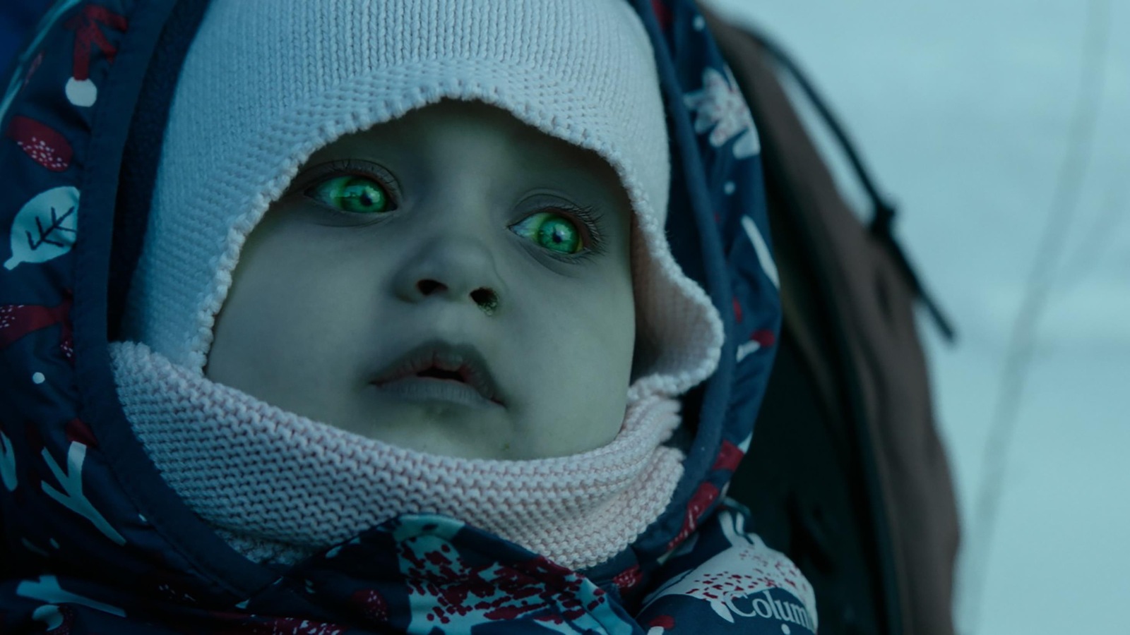Un bébé zombie aux yeux verts, dans un porte-bébé. Un bébé zombie aux yeux verts, dans un porte-bébé.