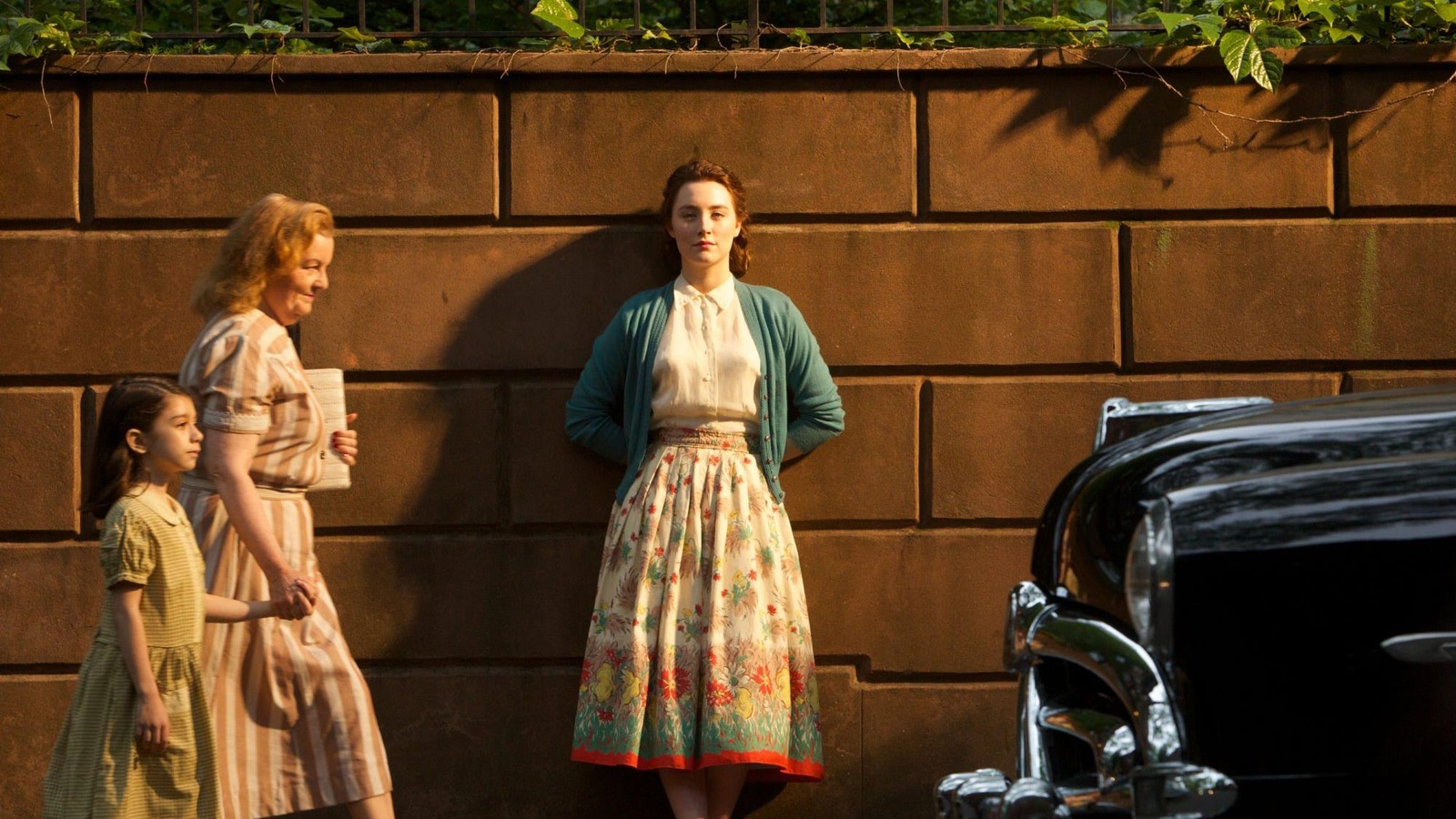 Une jeune femme (Saoirse Ronan) adossée contre un mur en pierres. Une jeune femme (Saoirse Ronan) adossée contre un mur en pierres.