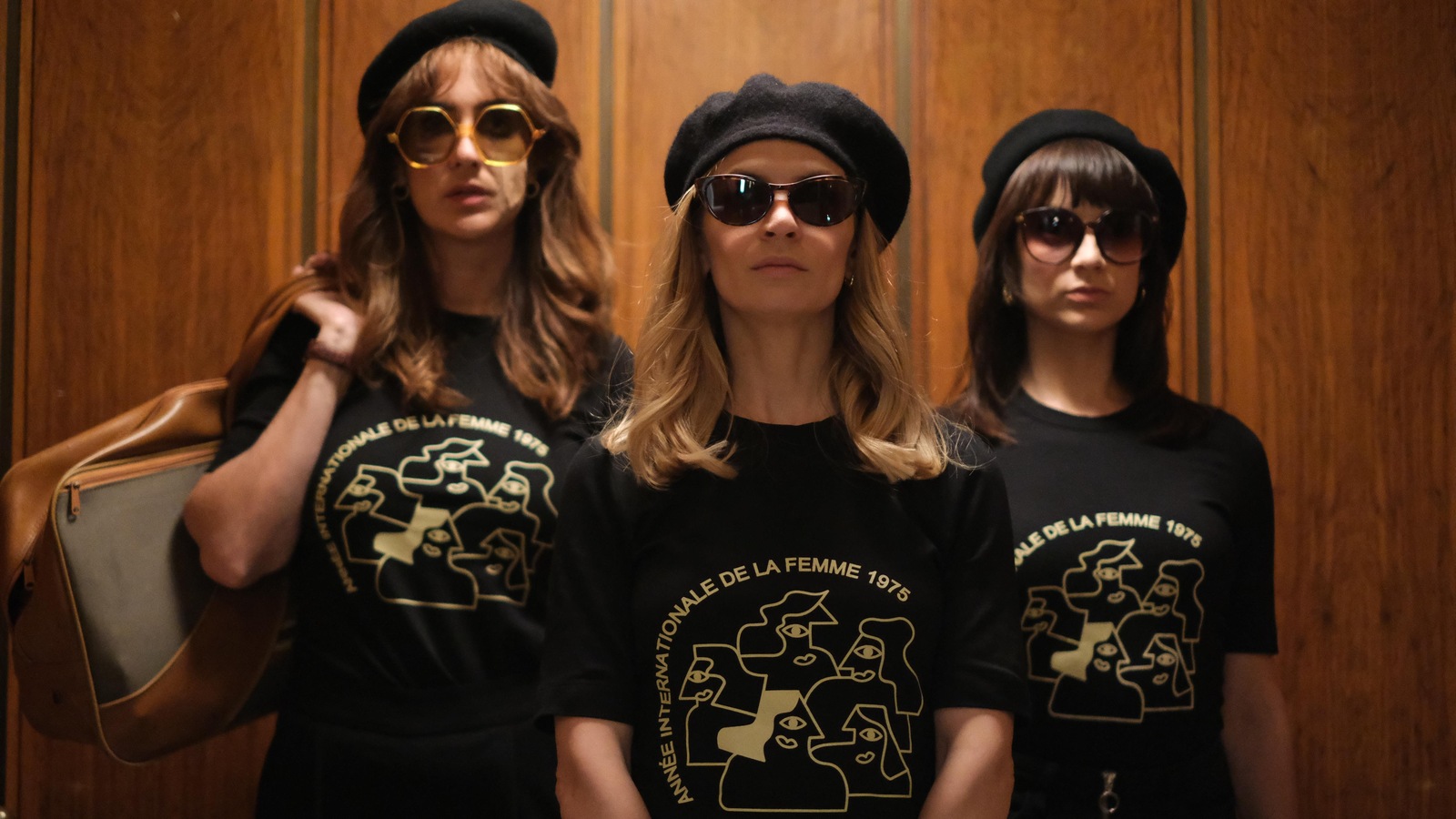 Micheline, Huguette et Marie-Josée portent un t-shirt de l'Année internationale de la femme 1975, des lunettes de soleil et un béret noir.
