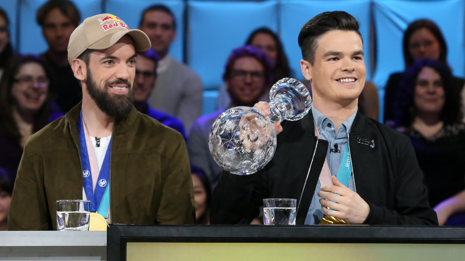 Ils arborent tous les deux leurs médailles. Mikaël tient son globe de cristal à la main. Ils arborent tous les deux leurs médailles. Mikaël tient son globe de cristal à la main.