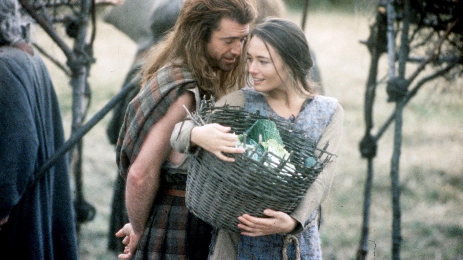 Un homme en plaid (Mel Gibson) derrière une femme portant un panier. Un homme en plaid (Mel Gibson) derrière une femme portant un panier.