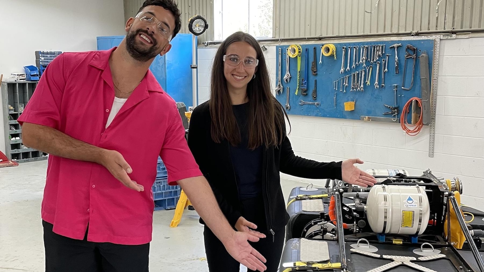 Les deux personnes sourient dans un atelier. Elles portent des lunettes protectrices. Les deux personnes sourient dans un atelier. Elles portent des lunettes protectrices.