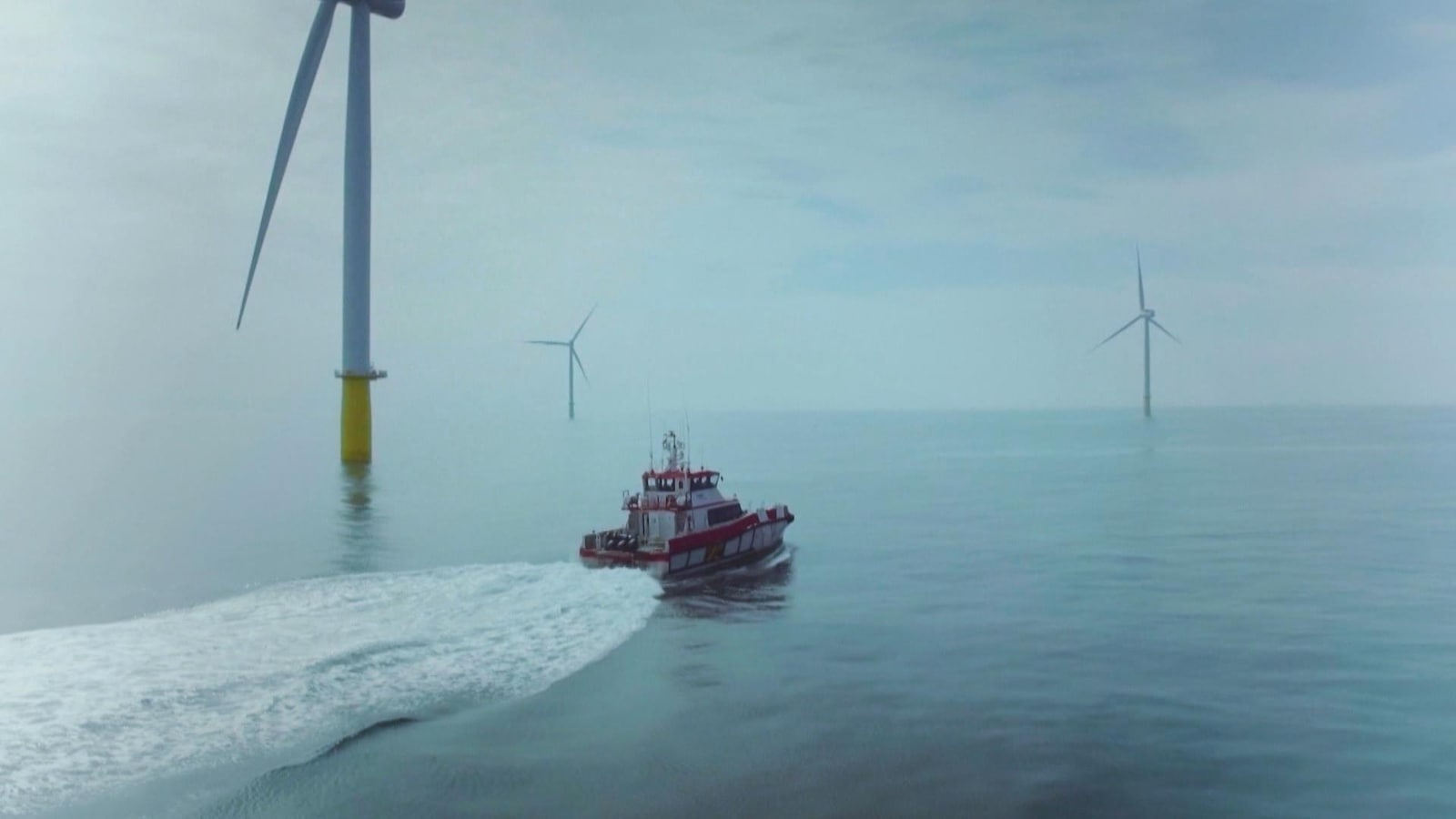 Un bateau passe au milieu d'éolienne en mer. Un bateau passe au milieu d'éolienne en mer.